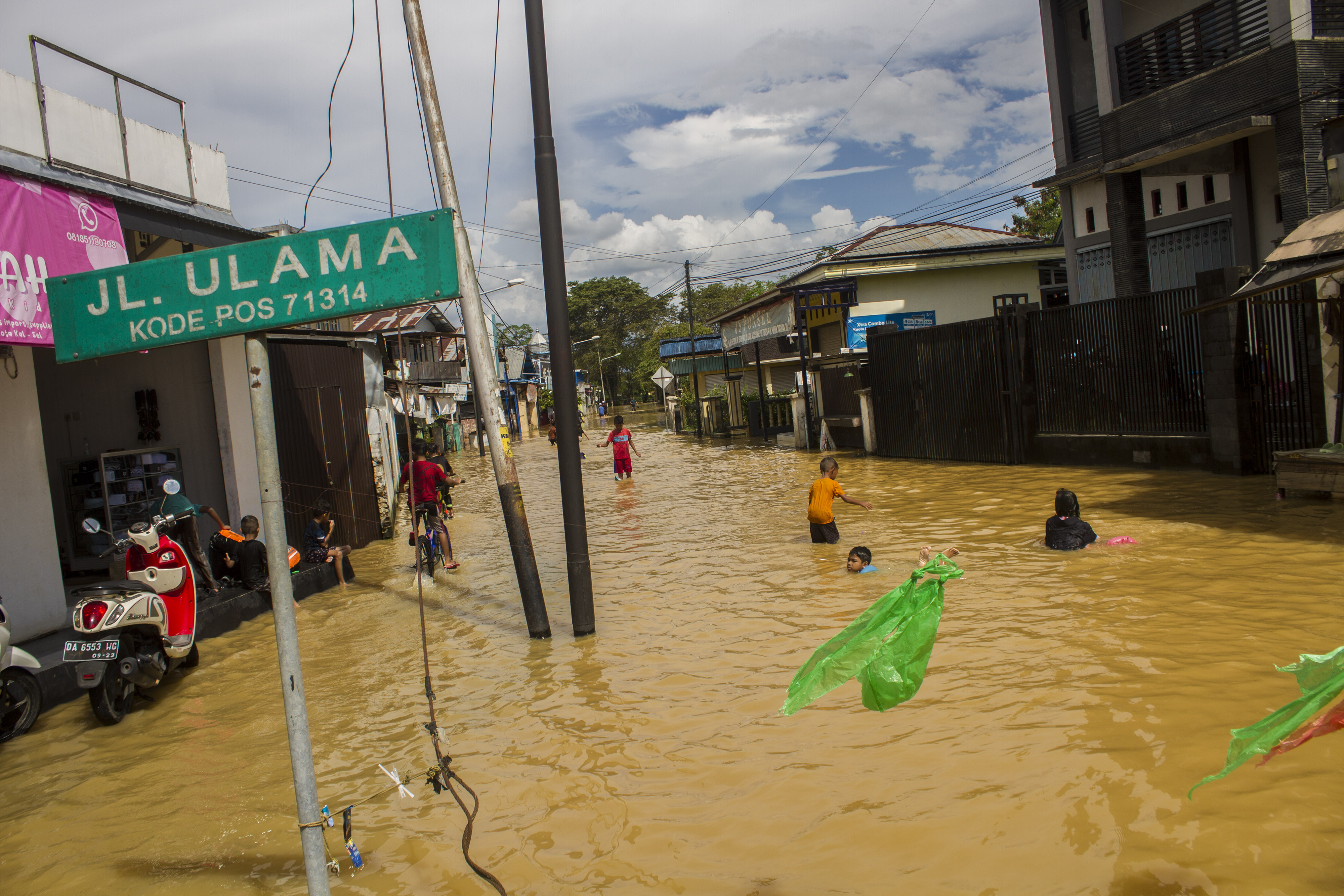 Anak-anak bermain air saat banjir di Barabai, Kabupaten Hulu Sungai Tengah, Kalimantan Selatan, Jumat (17/3/2023).