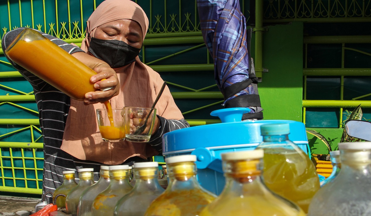 Penjual jamu keliling melayani pembeli di Makassar, Sulawesi Selatan.