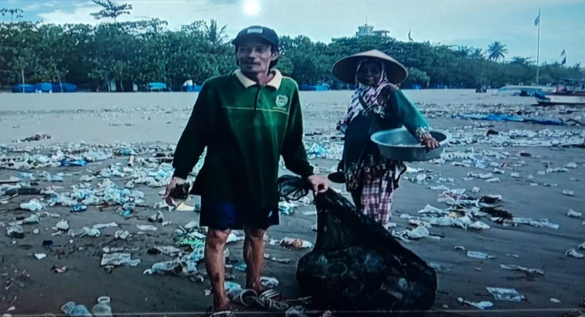 Pemulung sedang memungut sampah plastik dari beragam produk yang bertebaran di Pantai Pangandaran, Jawa Barat.