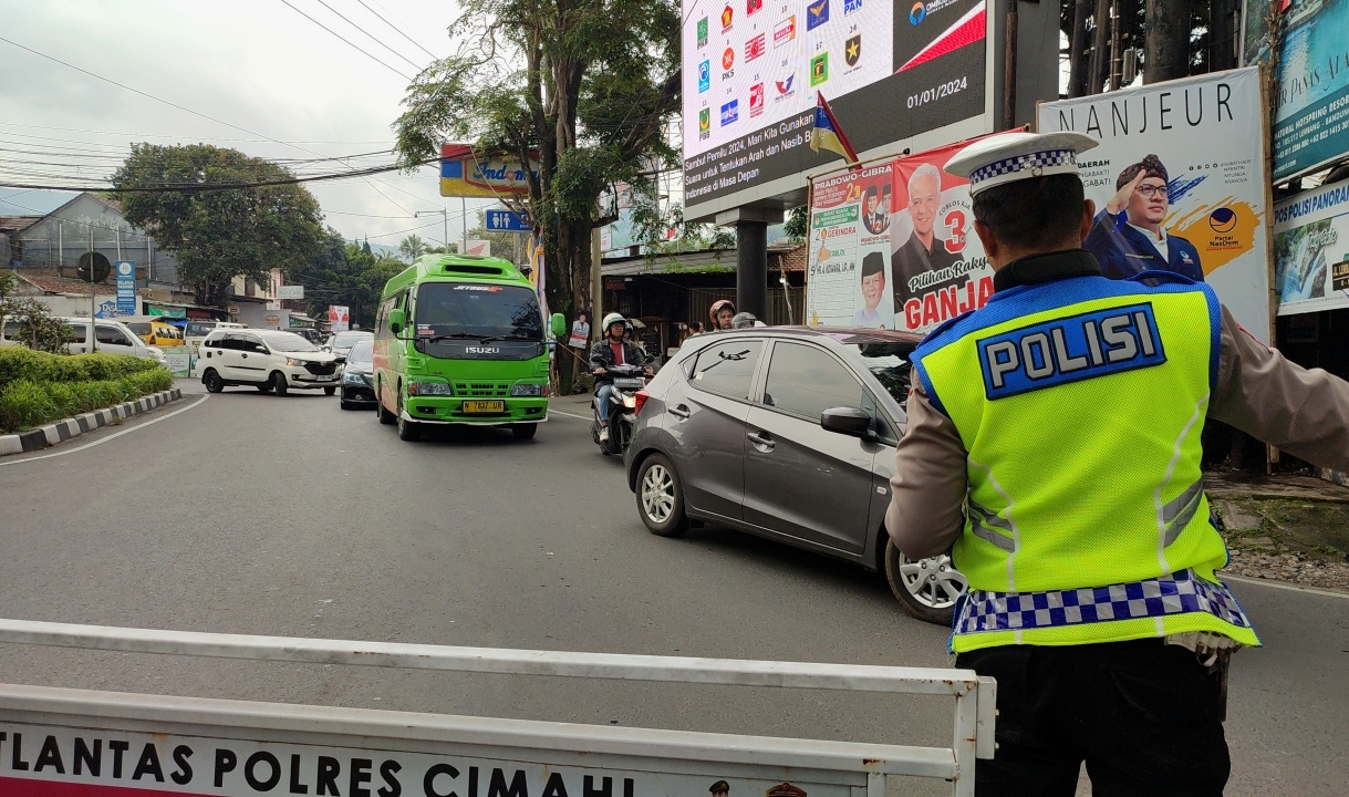 Anggota Satlantas Polres Cimahi mengatur arus lalu lintas di kawasan Lembang, Kabupaten Bandung Barat