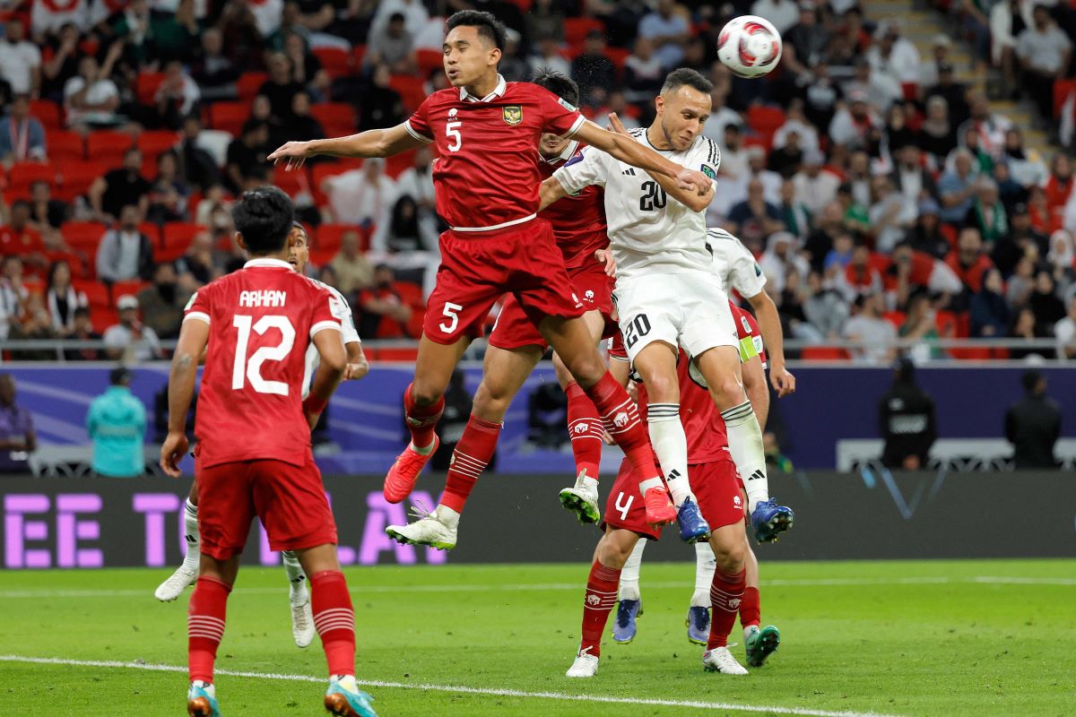 Pemain Timnas Indonesia berdual memperebutkan bola dengan pemain Irak.