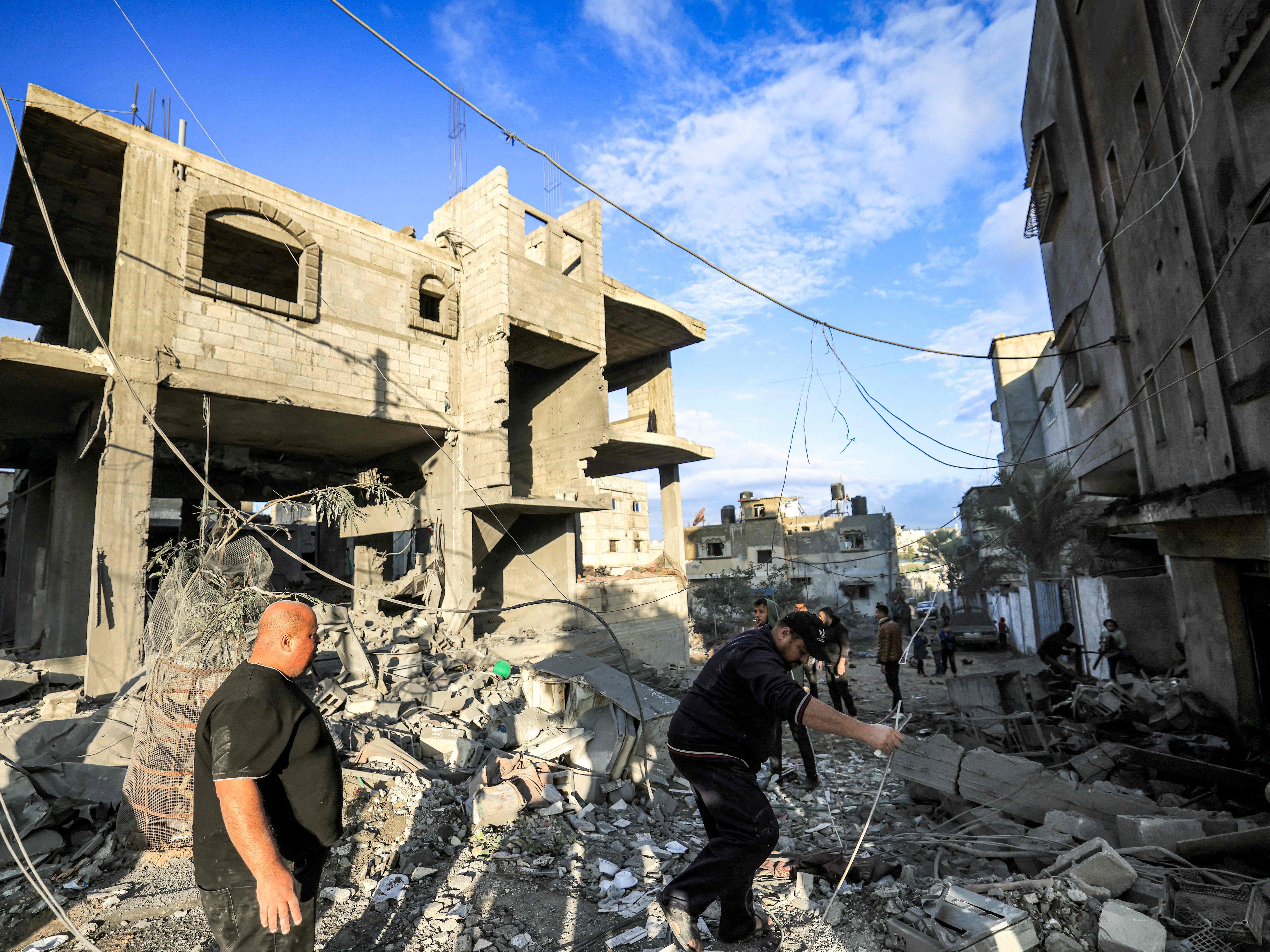 Orang-orang memeriksa puing-puing bangunan tempat keluarga pengungsi Palestina Jabalieh berlindung setelah pengeboman Israel di Rafah. 