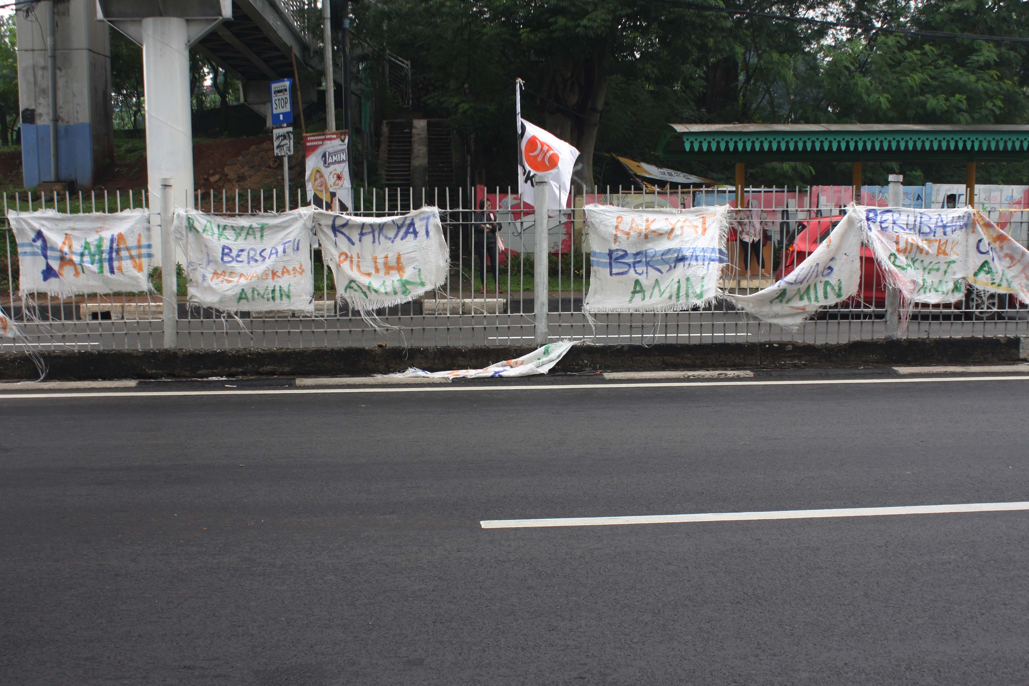 Jajaran spanduk dari karung -karung goni bertuliskan dukungan terhadap AMIN di Jalan Taman Mini (MI / M Irfan)