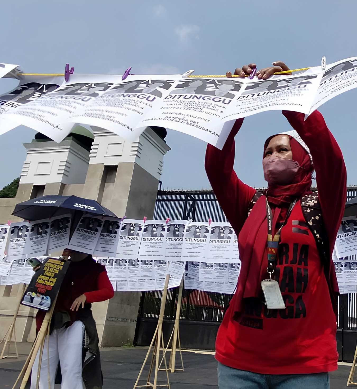 AKSI DEMO: Aktivis melakukan aksi protes di depan Gedung DPR, Jakarta. Mereka mendesak DPR untuk segera membahas dan mengesahkan RUU PPRT.
