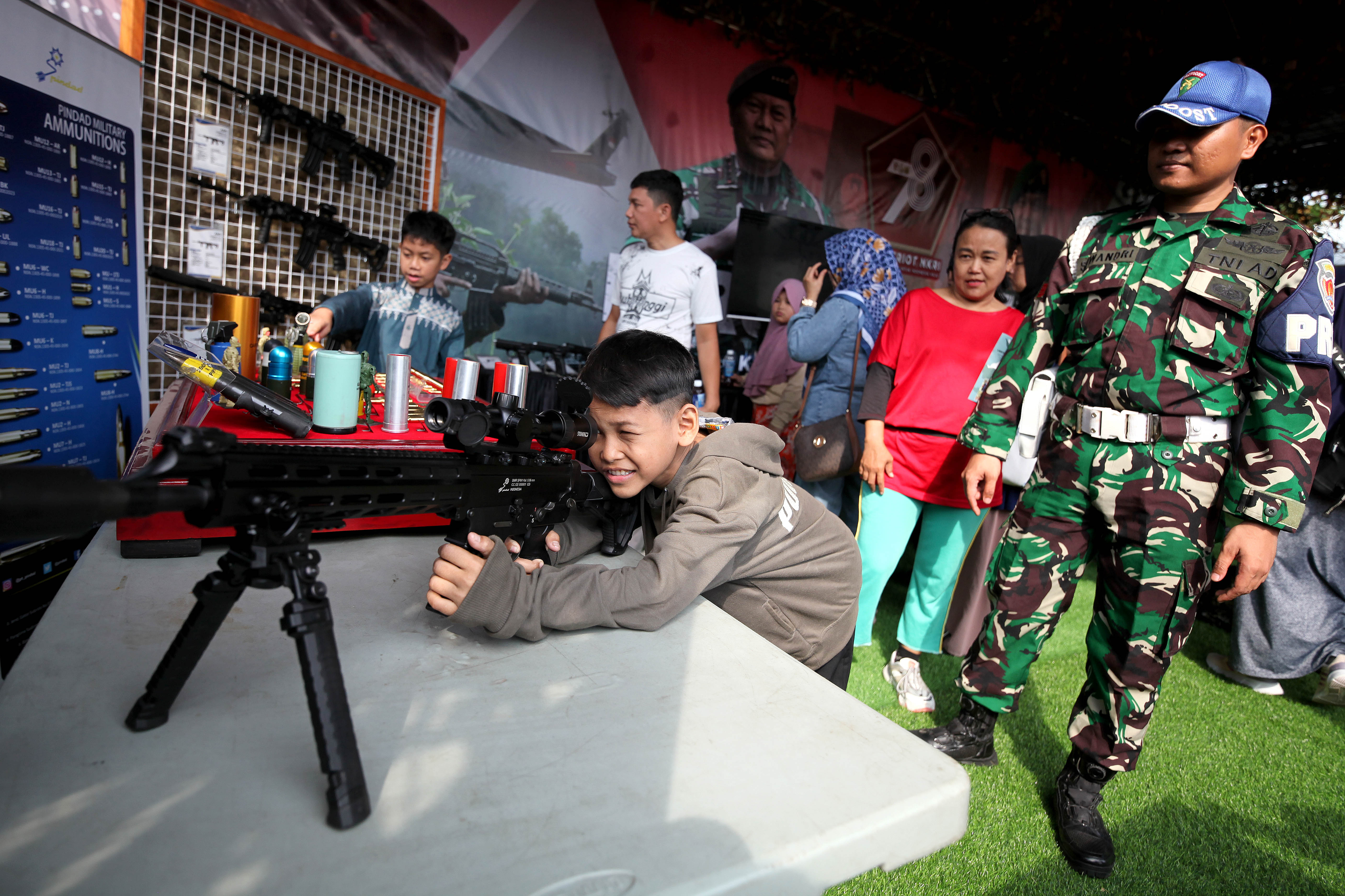 Masyarakat mencoba senjata yang digunakan dalam pameran alat utama sistem senjata (alutsista) TNI yang digelar di area Monas, Jakarta.