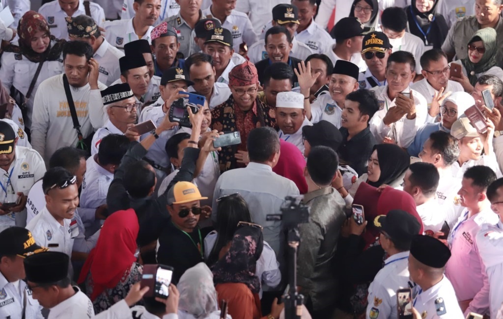 Capres Anies Baswedan mengenakan lacak khas Jambi dikerumuni para kepala desa yang menjadi peserta Rakernas Apdesi Tahun 2023 di Jambi.