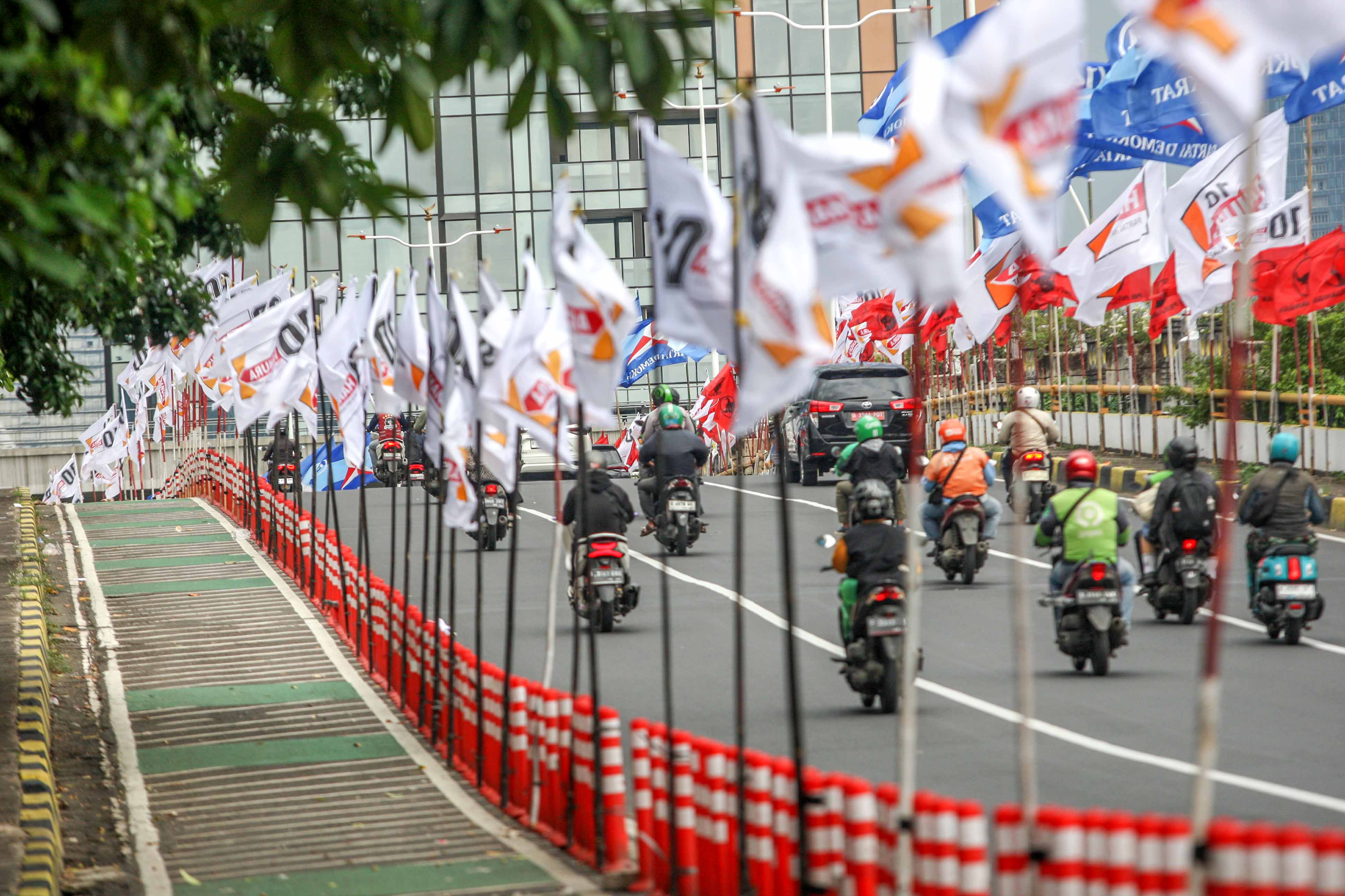 Ratusan bendera parpol terpasang di tiang pembatas jalur sepeda (stick cone) di Jalan Rasuna Said, Jakarta Selatan, Kamis (04/1/2024). 