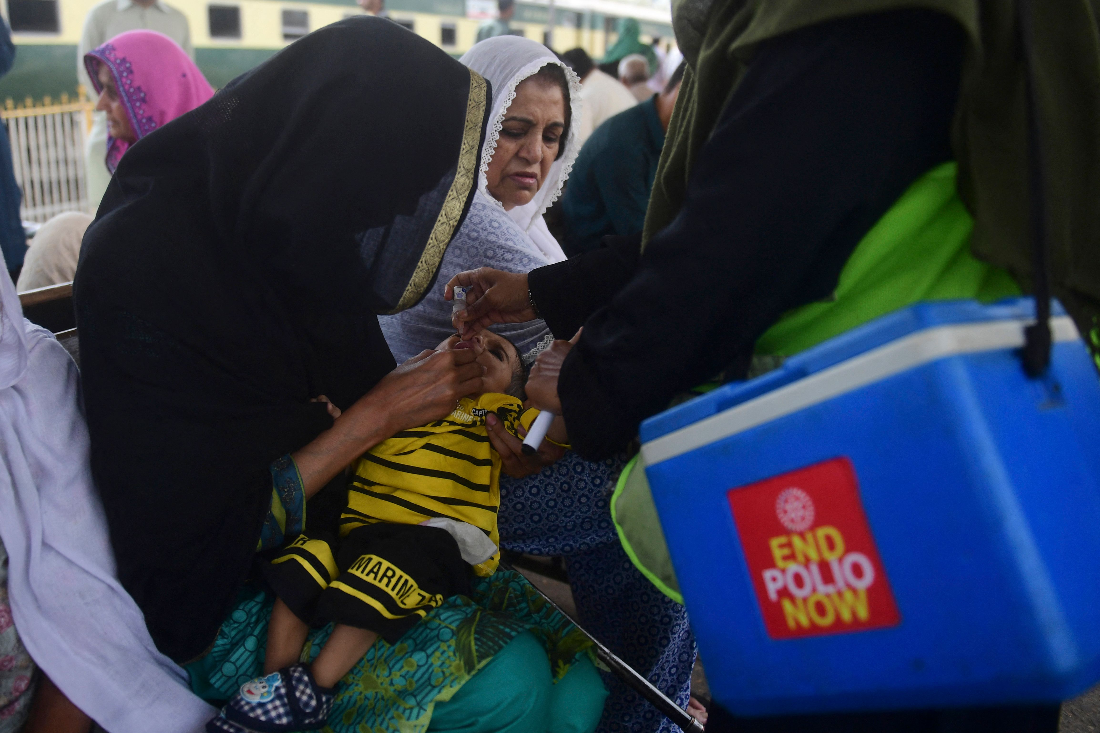 Petugas kesehatan memberikan vaksin polio ke seorang anak di Karachi, Pakistan.