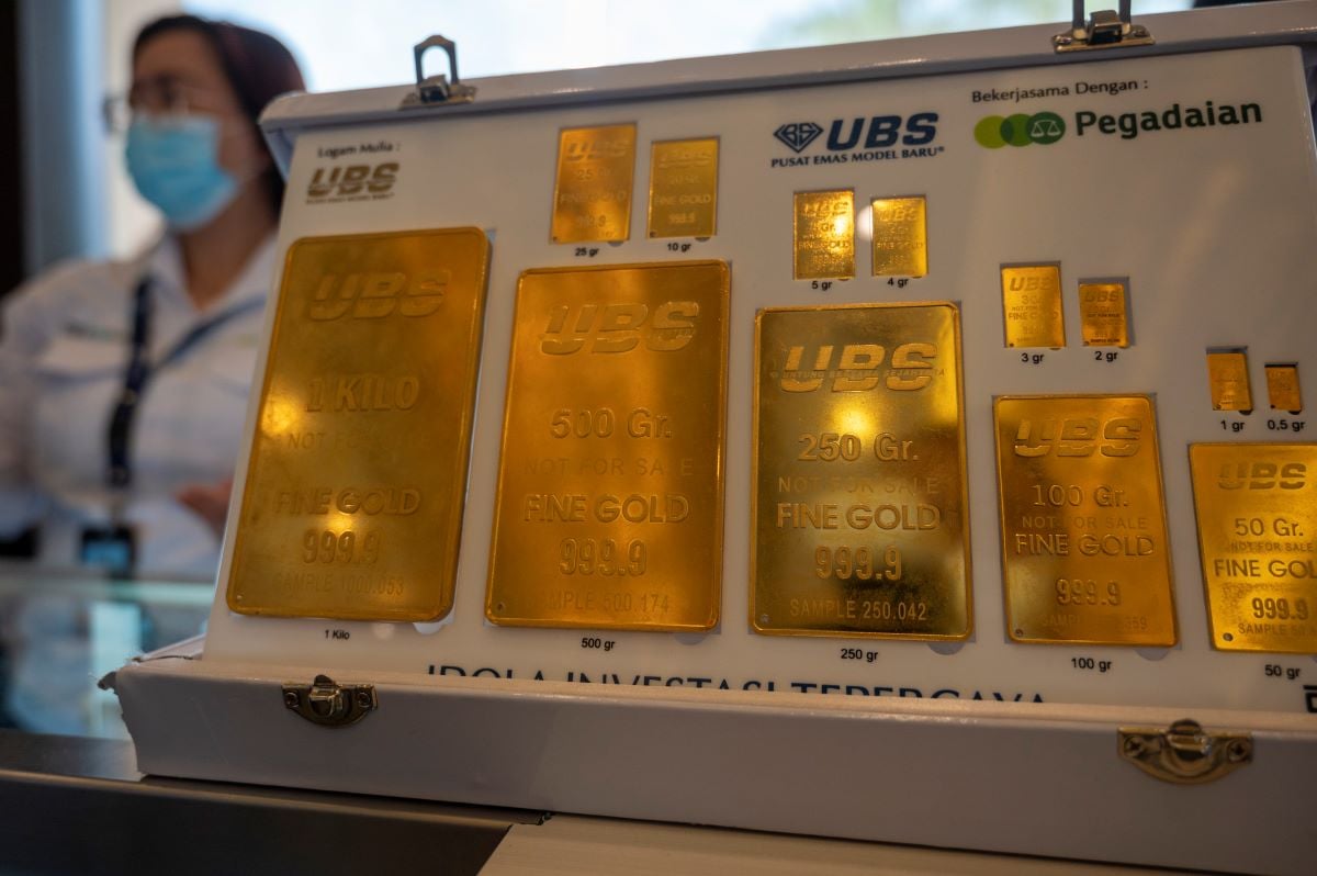 Pegawai bertugas di dekat pajangan emas cetakan UBS PT Pegadaian.