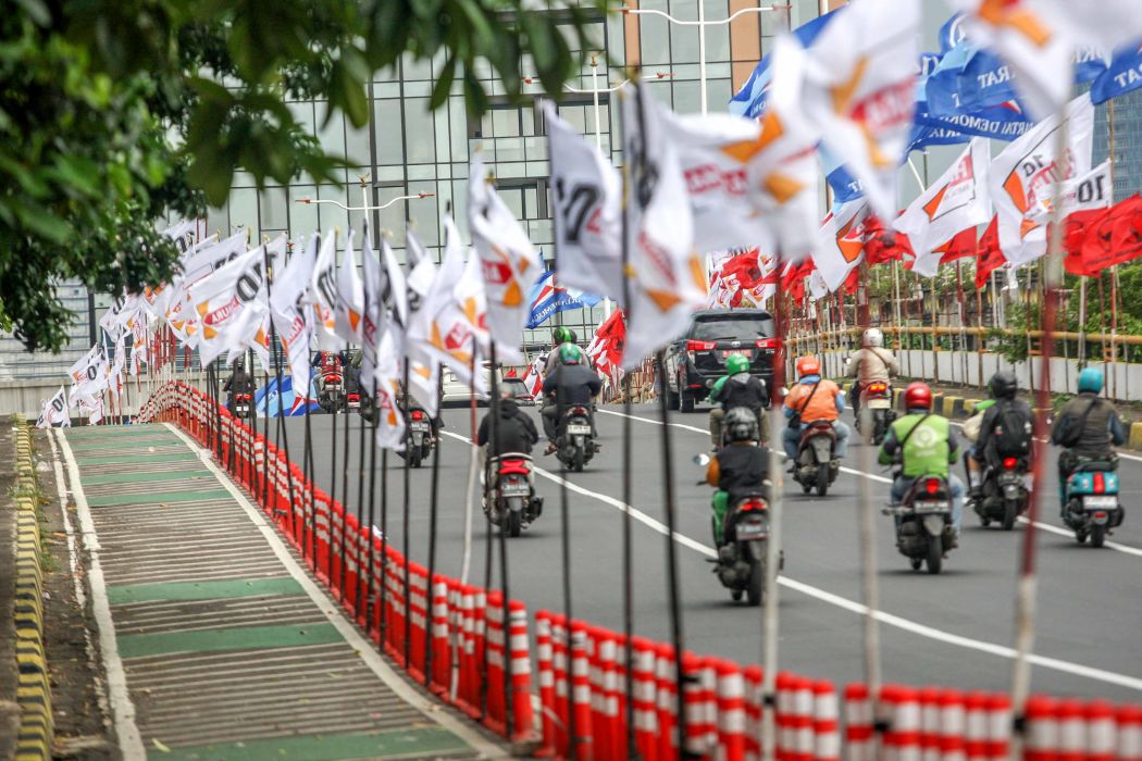 Ratusan bendera parpol terpasang di tiang pembatas jalur sepeda (stick cone) di Jalan Rasuna Said, Jakarta Selatan, Kamis (04/1/2024). 