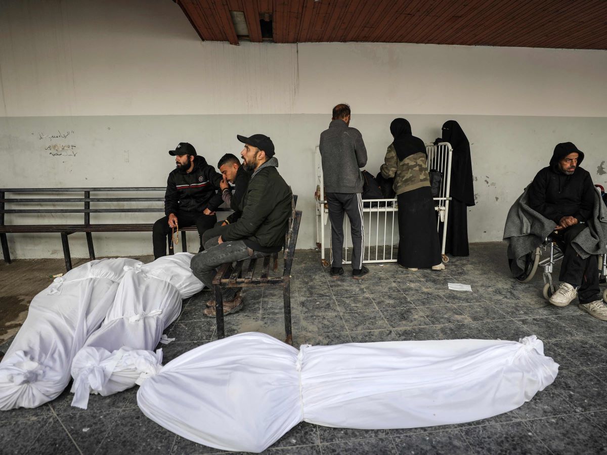 Warga Palestina duduk di dekat jenazah di luar rumah sakit Ahli Arabi, Kota Gaza, pada 31 Januari 2024.