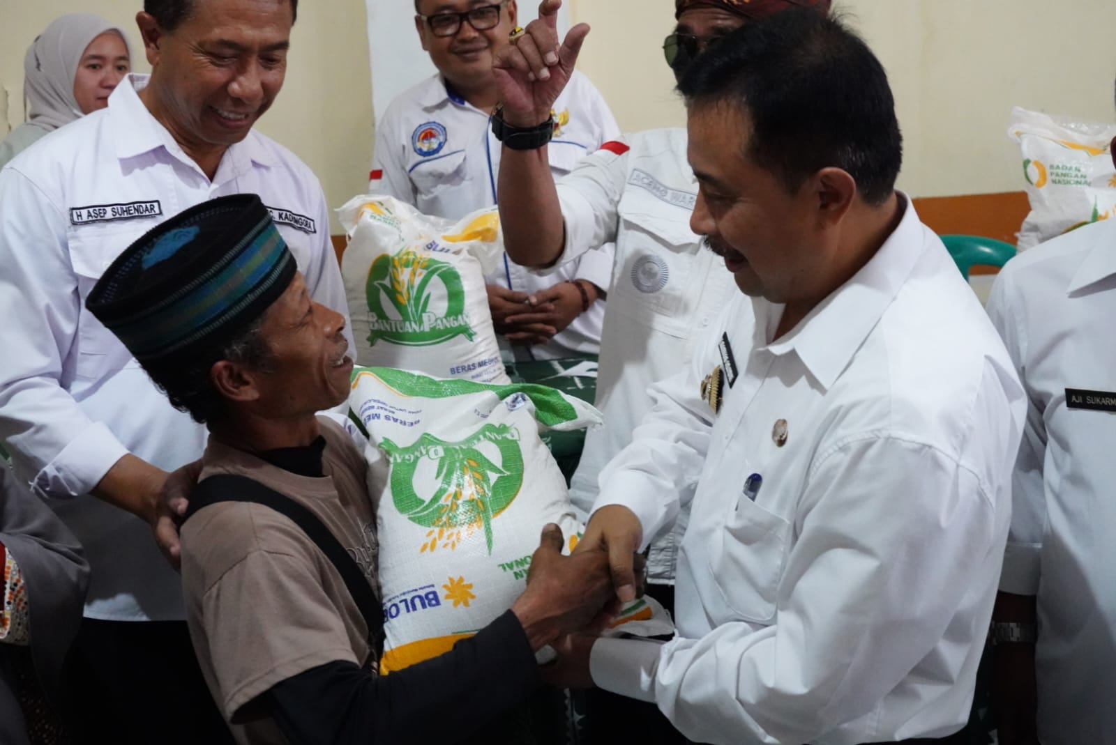 Penjabat (Pj) Bupati Garut, Barnas Adjidin menyerahkan bantuan beras cadangan pemerintah kepada warga