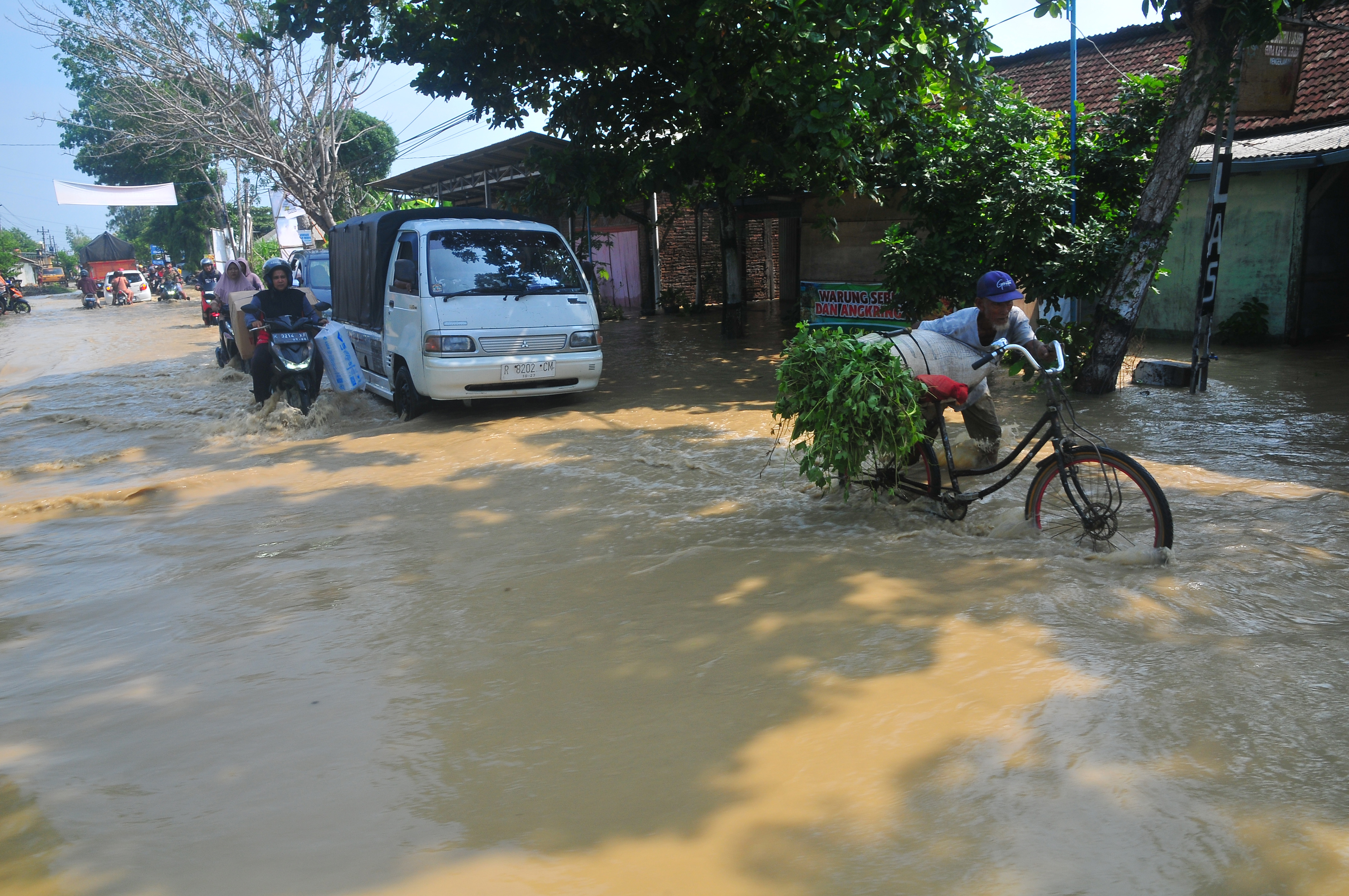 Sejumlah pengendara melintasi jalan Gubug-Salatiga yang terdampak banjir di Gubug, Grobogan, Jawa Tengah, Selasa (2/1).
