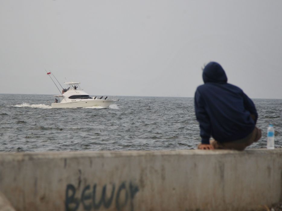 Warga duduk di Tanggul Muara Baru Jakarta