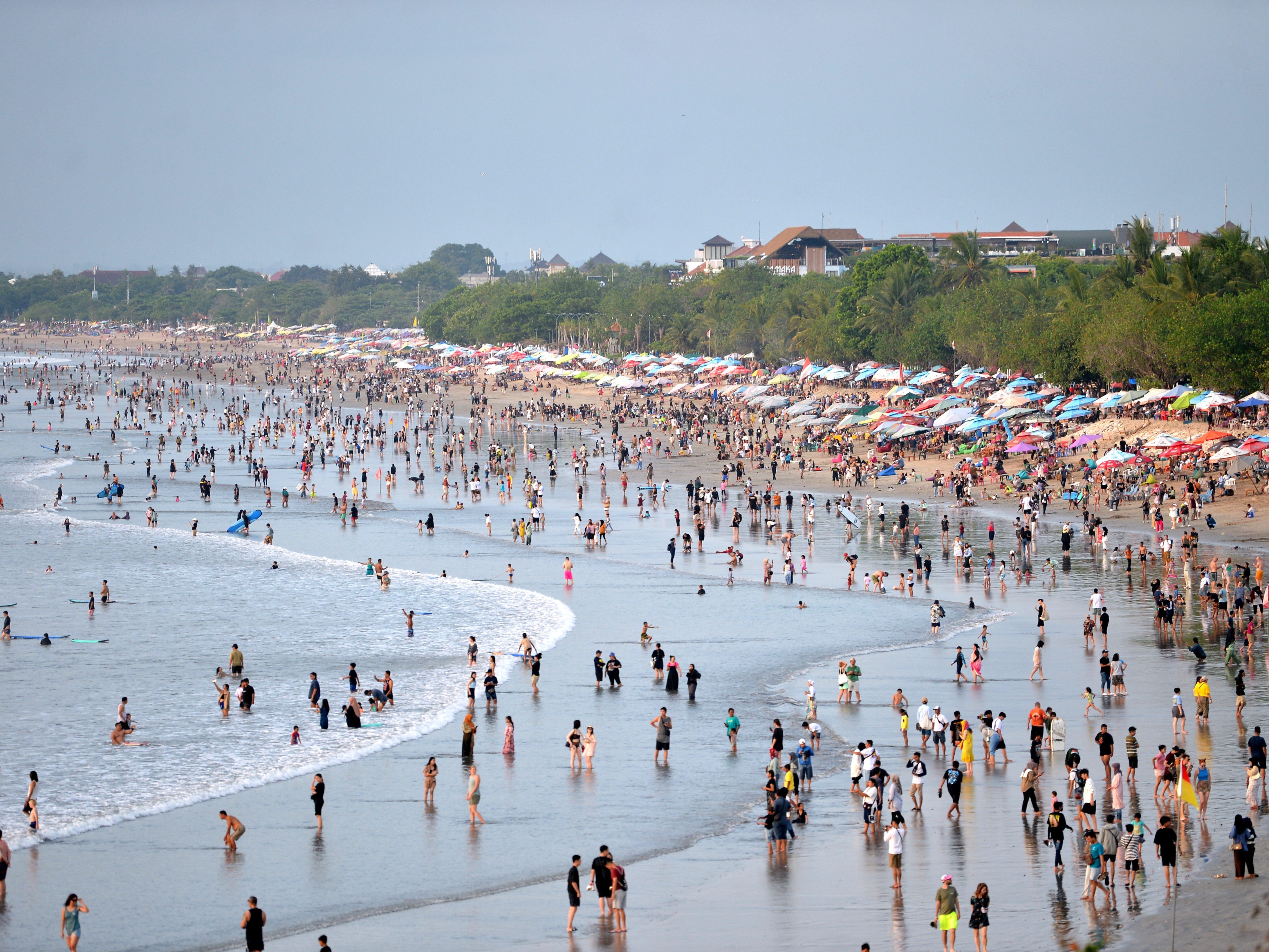 Wisatawan memadati kawasan wisata Pantai Kuta, Badung, Bali, Minggu (31/12/2023).