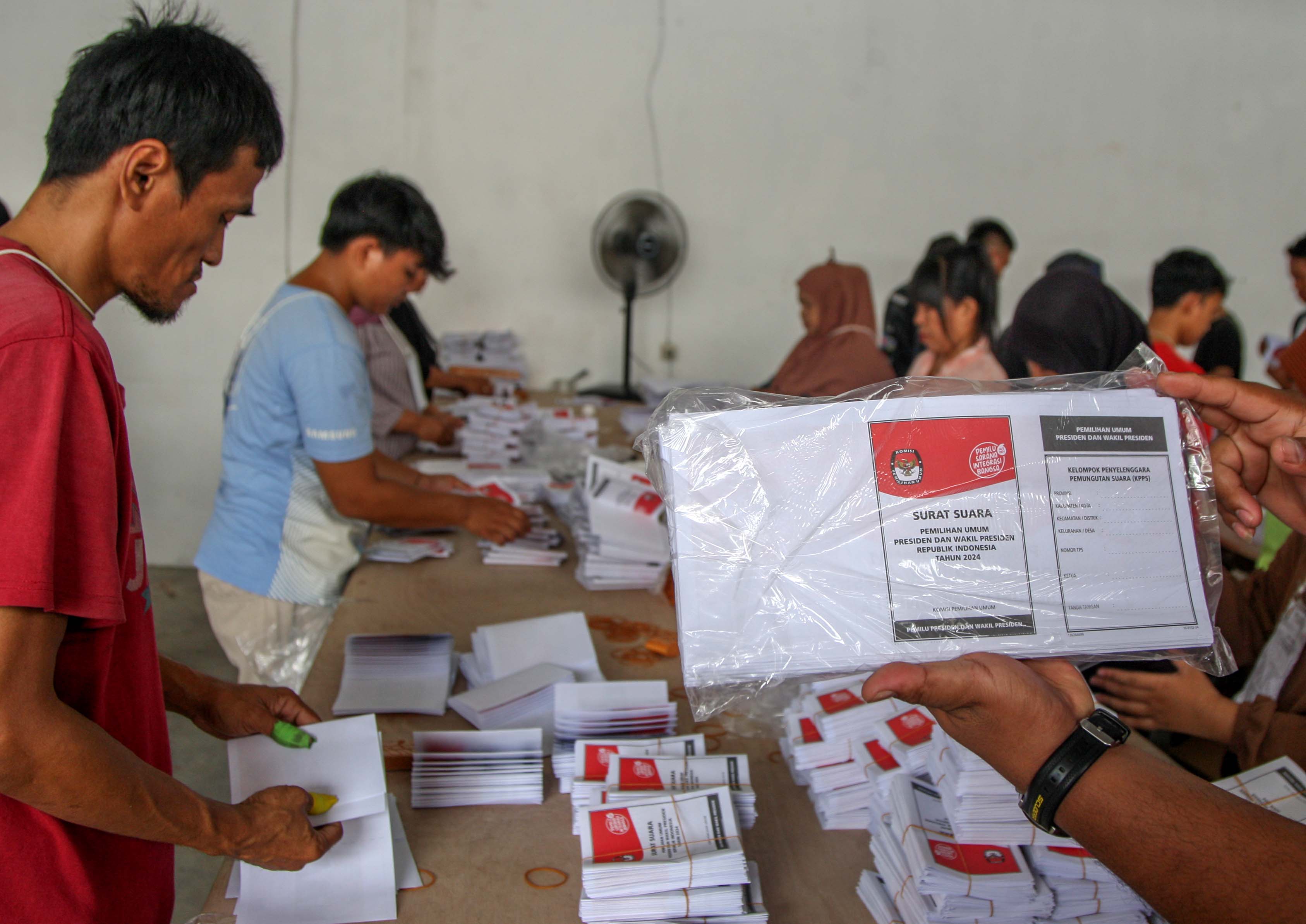 Pekerja memperlihatkan surat suara rusak karena salah cetak saat menyortir dan melipat surat suara Pemilu Presiden-Wakil Presiden 2024.