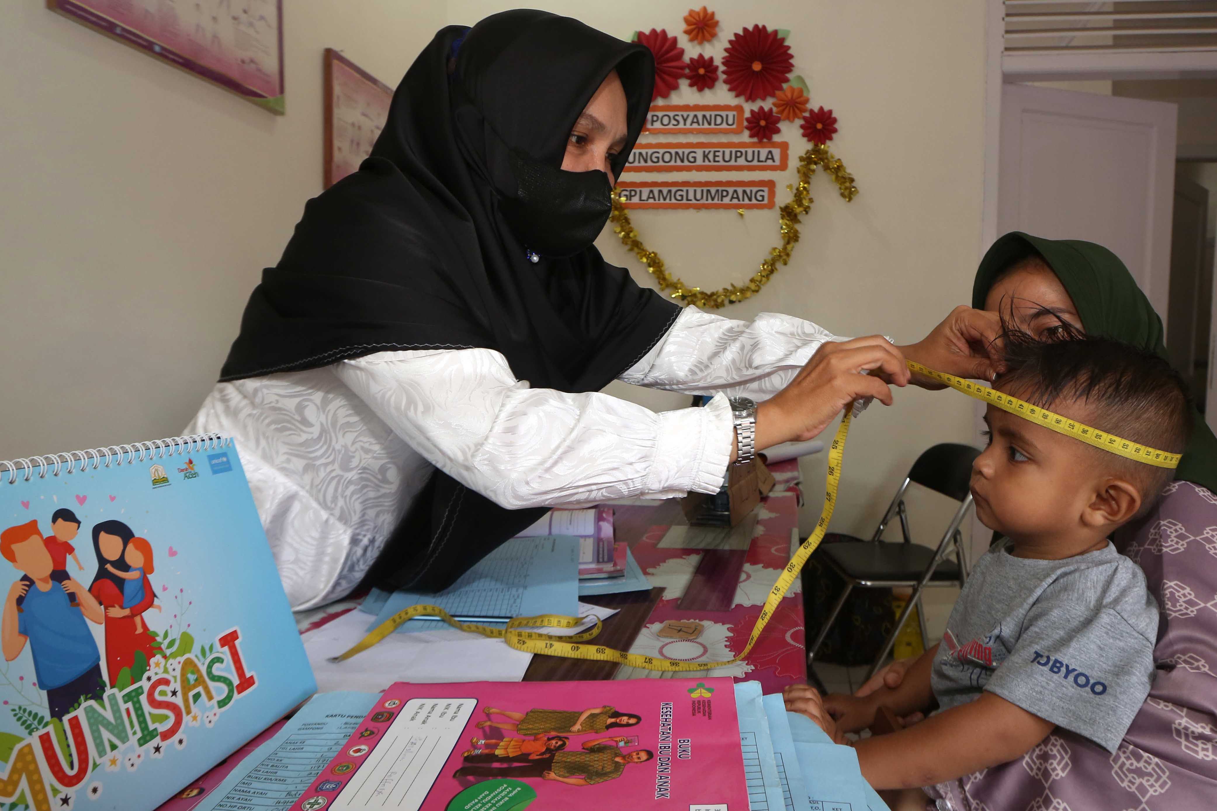 Ilustrasi. Petugas kesehatan mengecek pertubuhan fisik balita saat kegiatan pelayanan imunisasi di Banda Aceh, Aceh, Rabu (9/8/2023).