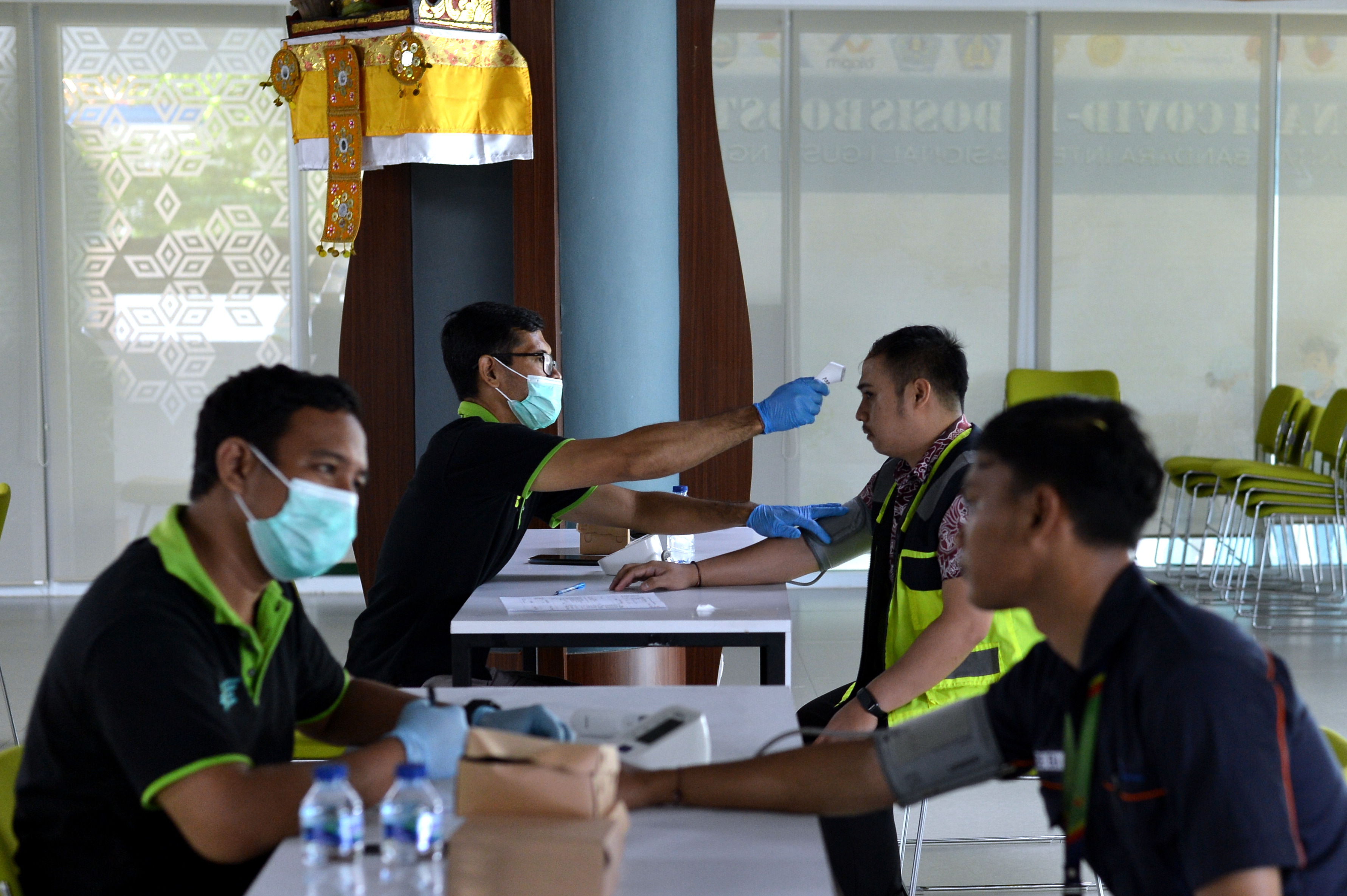 Ilustrasi. Petugas kesehatan melakukan pemeriksaan awal terhadap petugas komunitas Bandara I Gusti Ngurah Rai yang akan divaksin