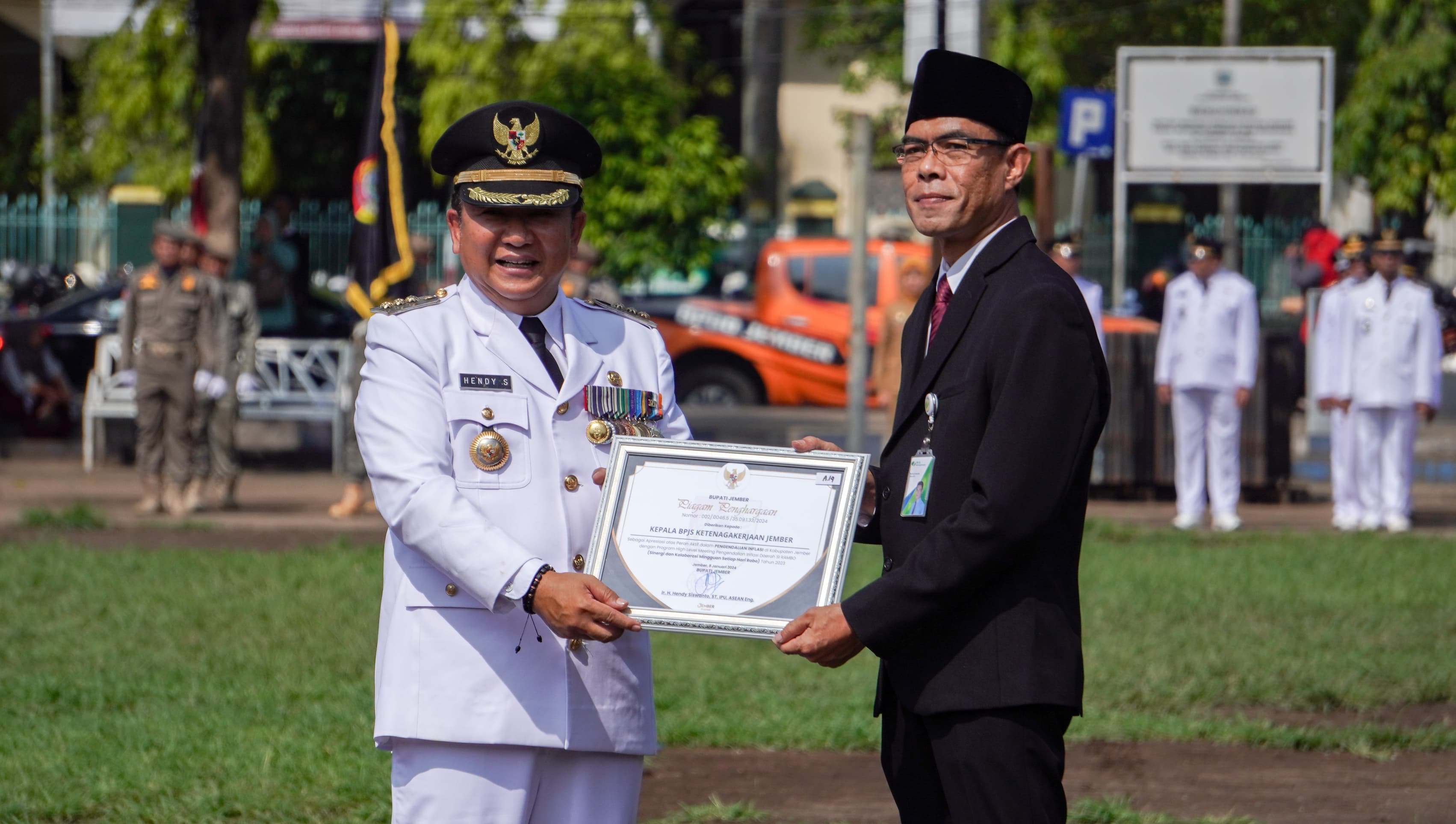 Kepala Kantor BPJS Ketenagakerjaan Cabang Jember Dadang Komarudin memberi penghargaan kepada Bupati Jember Hendy. 