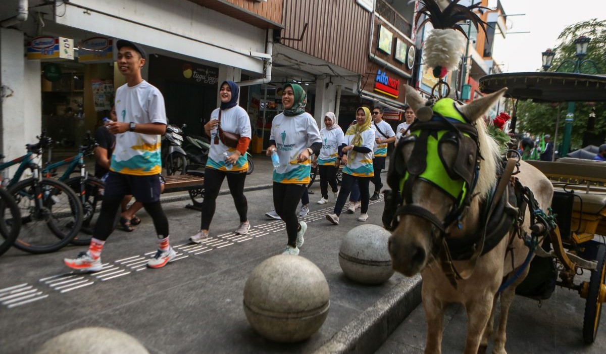 Ilustrasi: pelari mengambil botol plastik saat aksi lari sambil membersihkan lingkungan dari sampah plastik di Malioboro