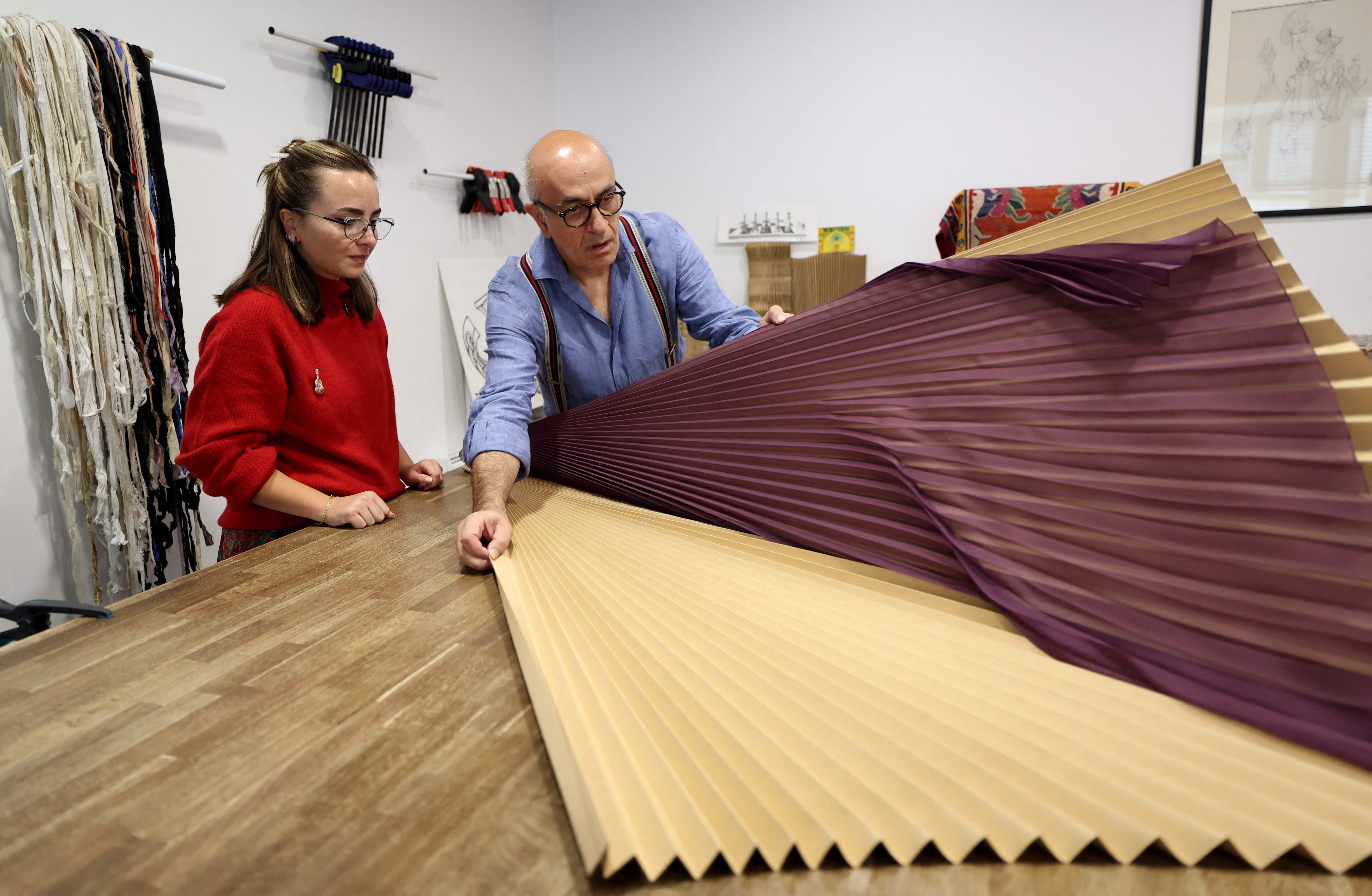 Seorang master lipit (baju biru) di Paris, Prancis, menunjukkan cara pembuatan kain lipit (pleats).