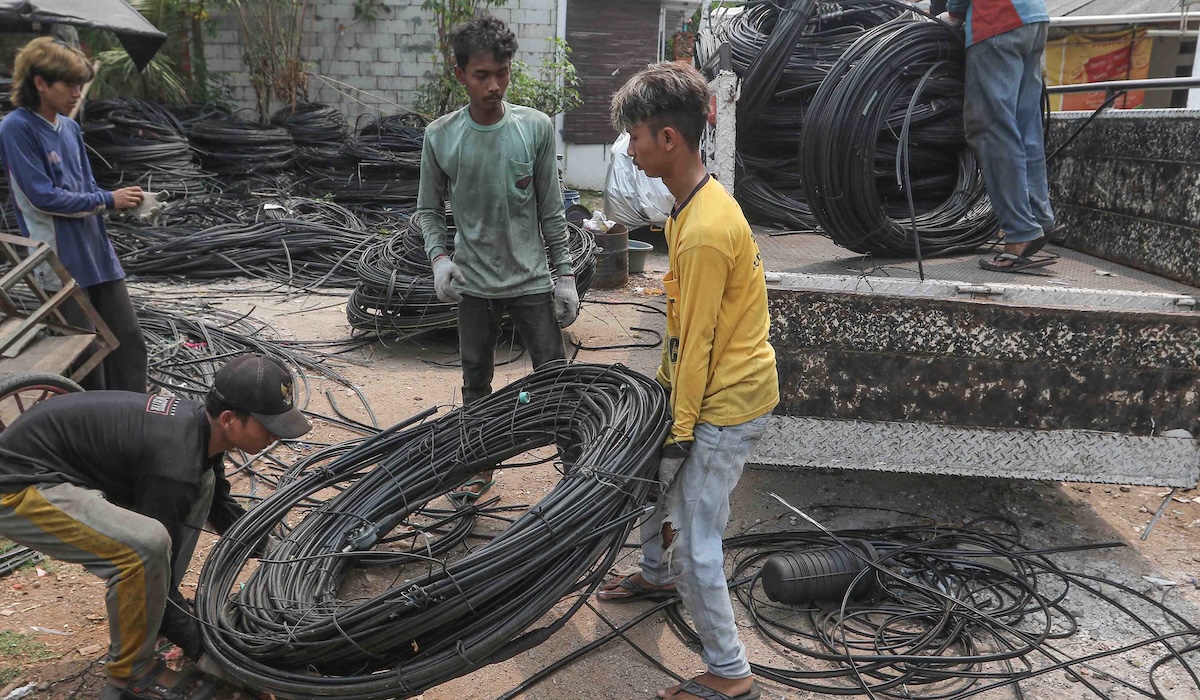 Pekerja mengumpulkan limbah kabel serat optik