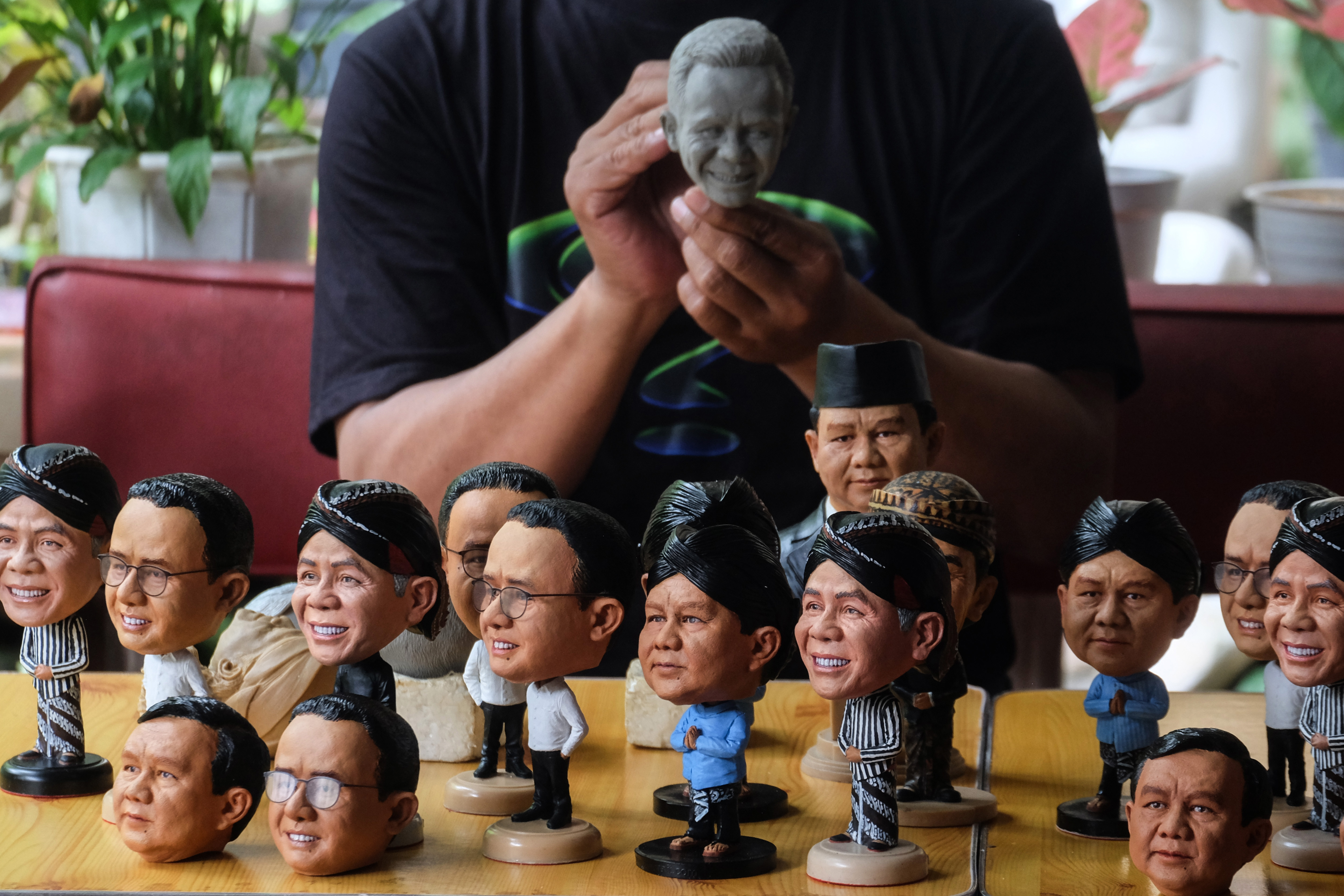 Perajin menyelesaikan pesanan mini action figur karakter calon Presiden 2024 di Solo, Jawa Tengah, Selasa (6/2).
