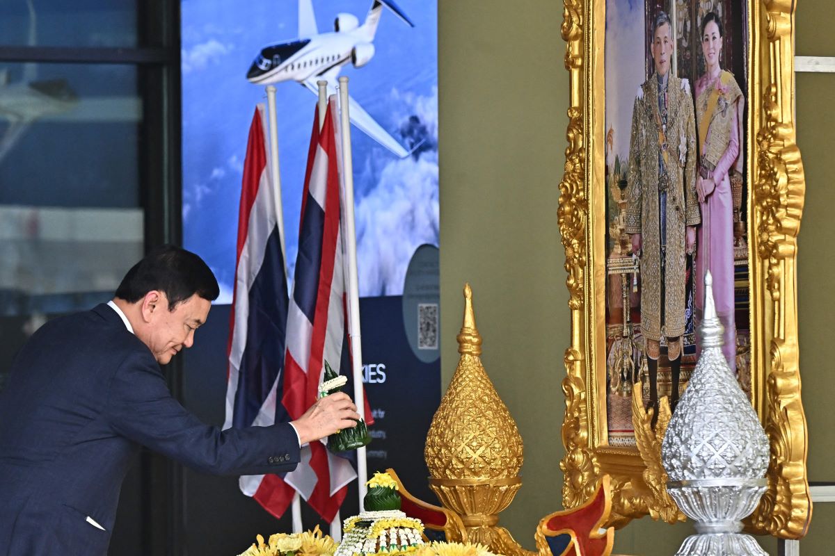 Eks PM Thailand Thaksin Shinawatra memberi penghormatan kepada potret raja setelah mendarat di bandara Bangkok pada 2023.
