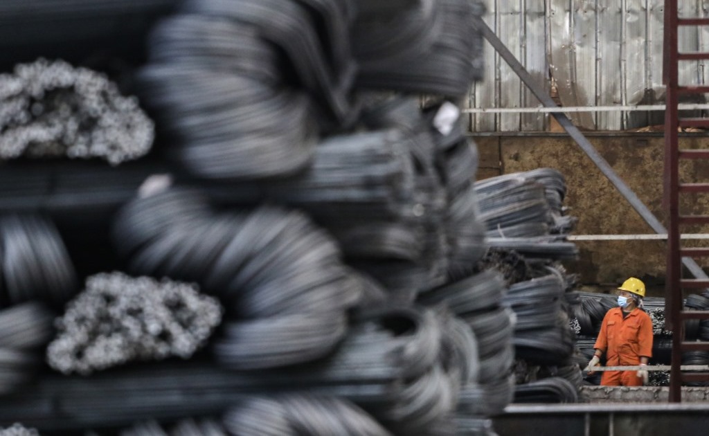 Pekerja beraktivitas di pabrik baja.