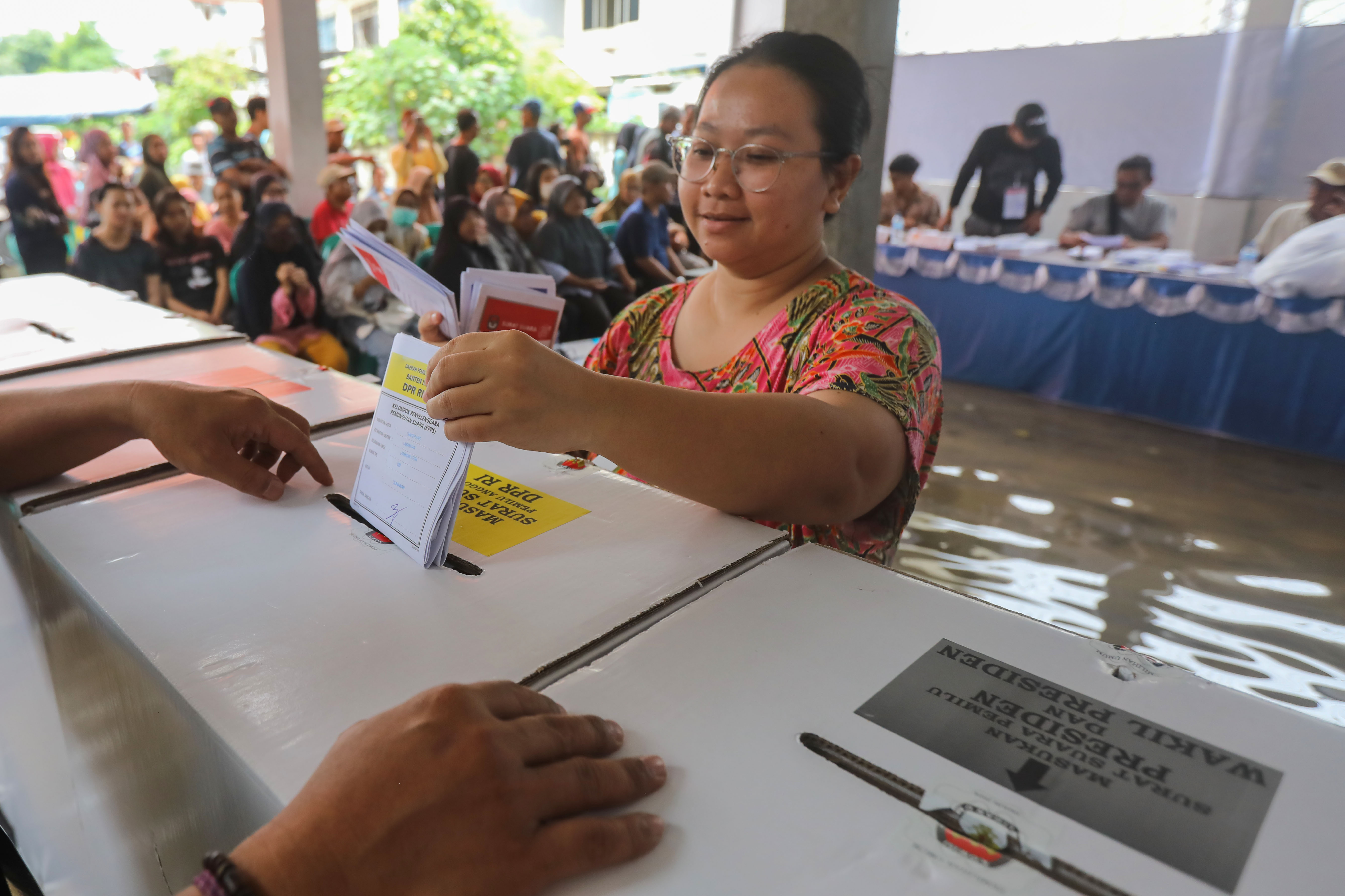Warga memasukkan surat suara ke dalam kotak setelah melakukan pencoblosan di Larangan, Kota Tangerang, Banten, Rabu (14/2).
