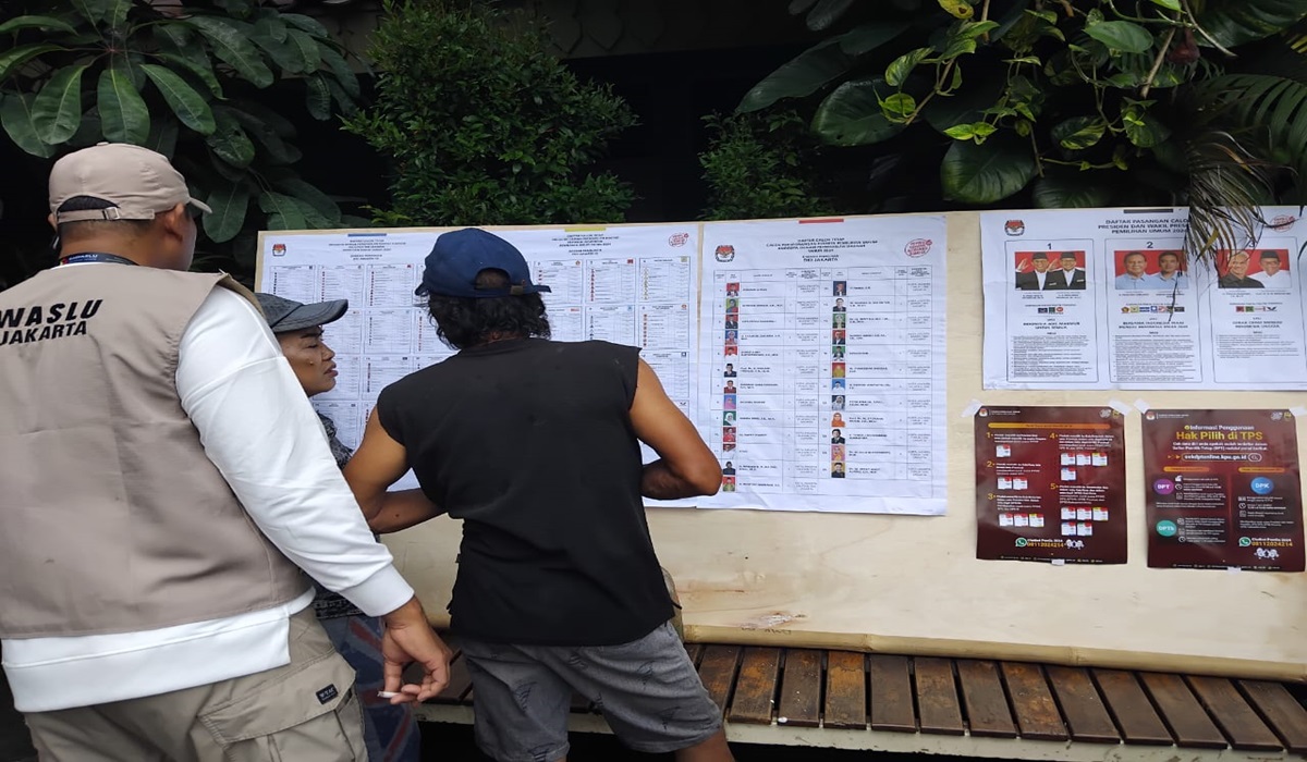 Warga melihat nama dan foto calon anggota DPR RI, DPRD Provinsi, DPRD Kabupaten/Kota, dan DPD di TPS. Rabu (14/2).