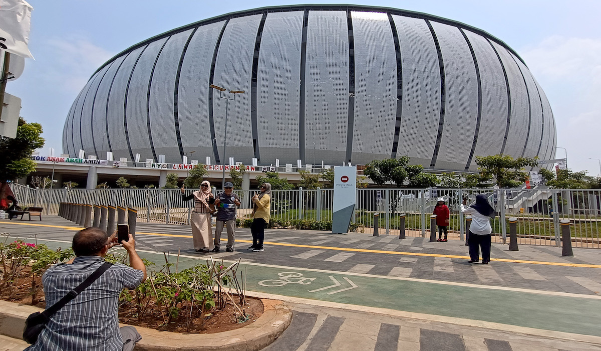 Warga berfoto di depan stadion yang akan digunakan Capres dan Cawapres 01, Anies Baswedan dan Muhaimin Iskandar untuk kampanye akbar.