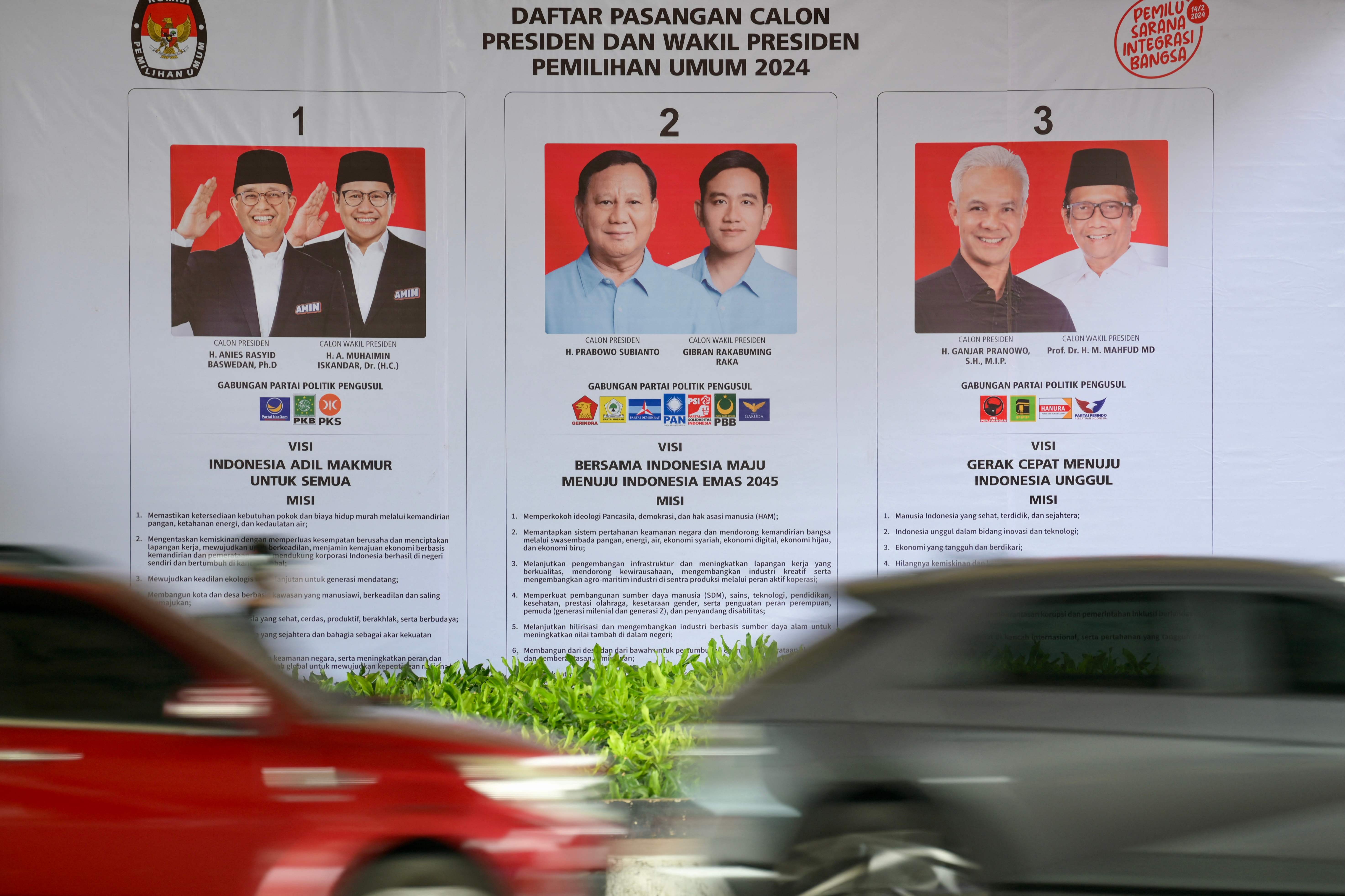 Pengendara melintasi poster daftar peserta Pilpres 2024 di Jakarta, Kamis (8/2).