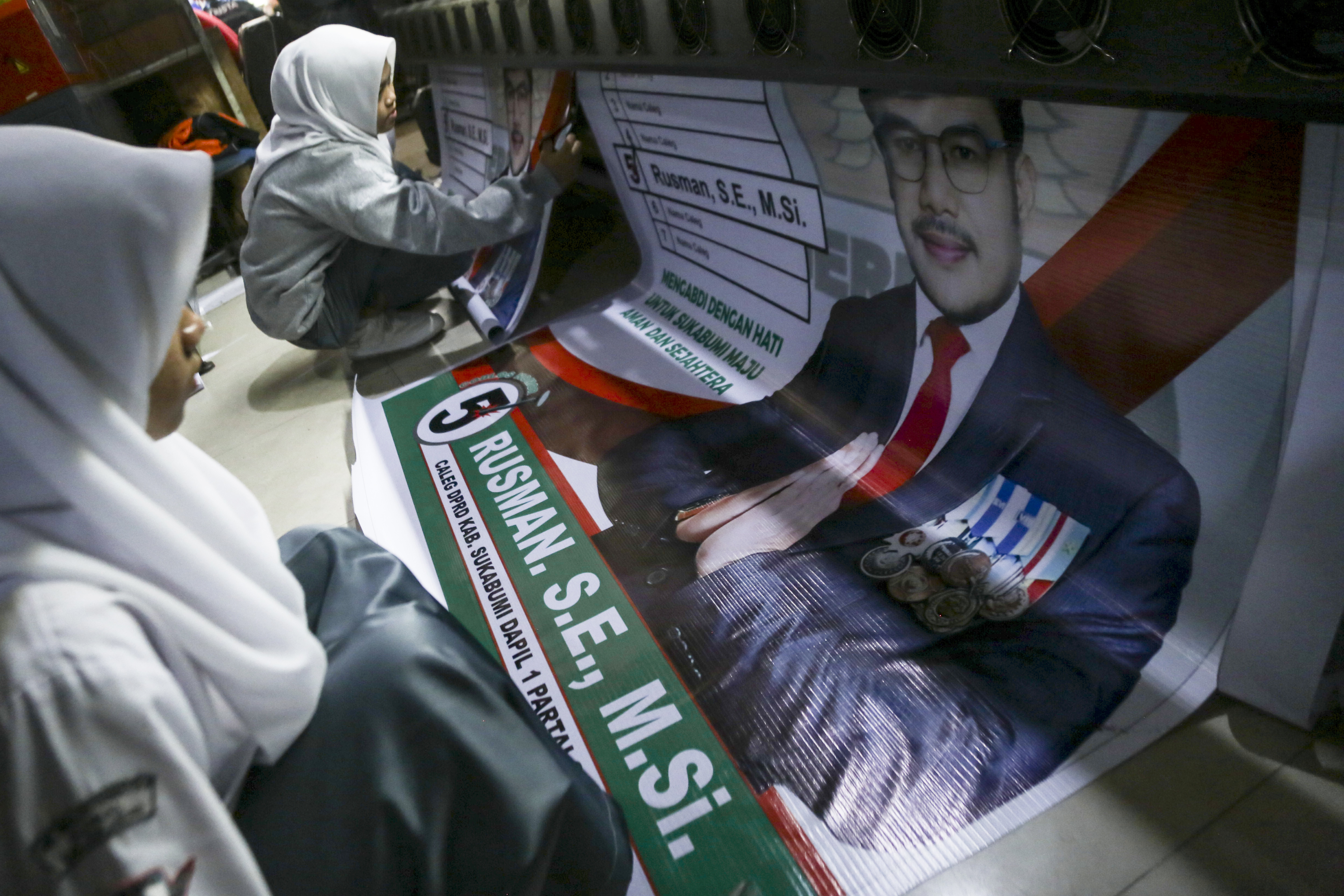  Siswi praktek lapangan memeriksa cetakan alat peraga kampanye di Kota Sukabumi, Jawa Barat, Selasa (28/11/2023)