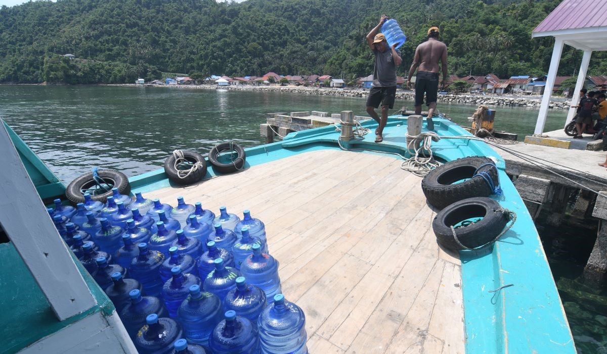 Pekerja mengangkut galon berisi air minum ke dalam kapal di Morowali, Sulawesi Tengah