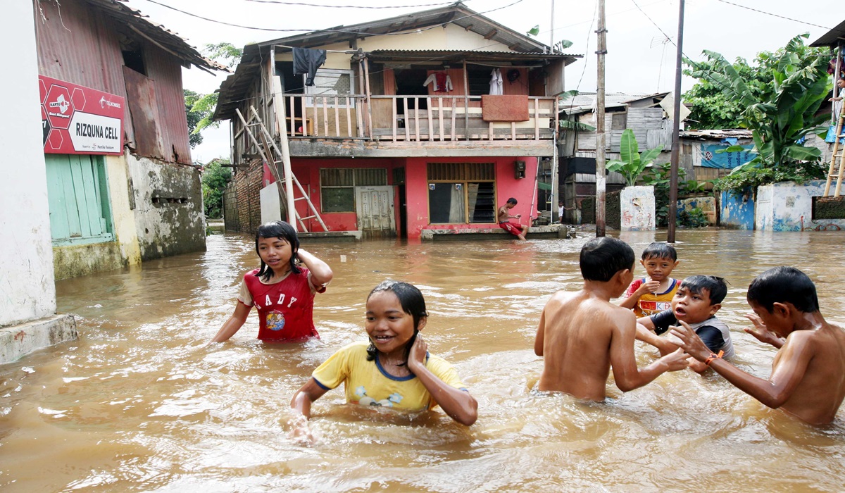 Sejumlah anak bermain air banjir di kampung Melayu Kecil, Bukit Duri, Jakarta Timur