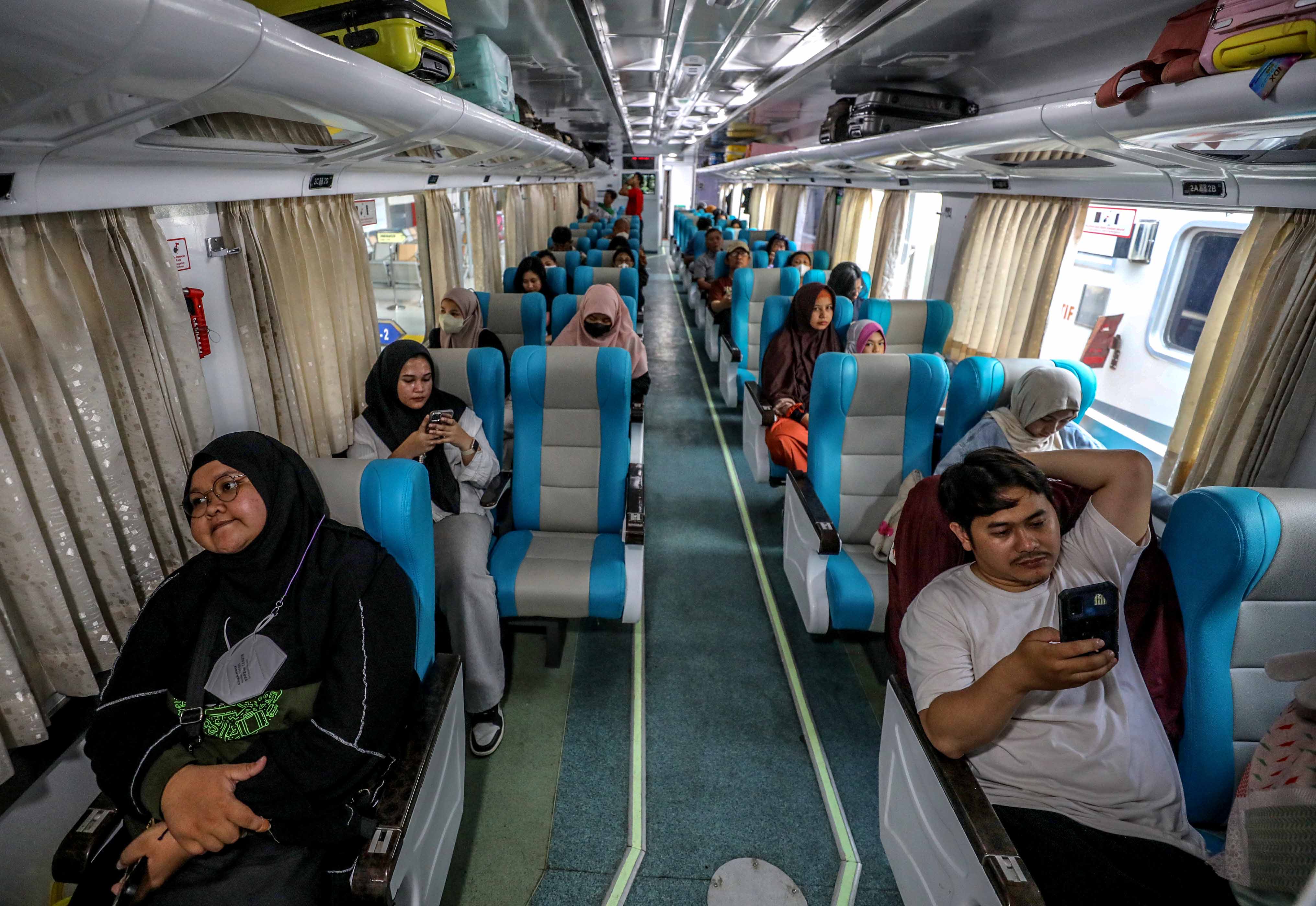 Penumpang menaiki gerbong kereta api 