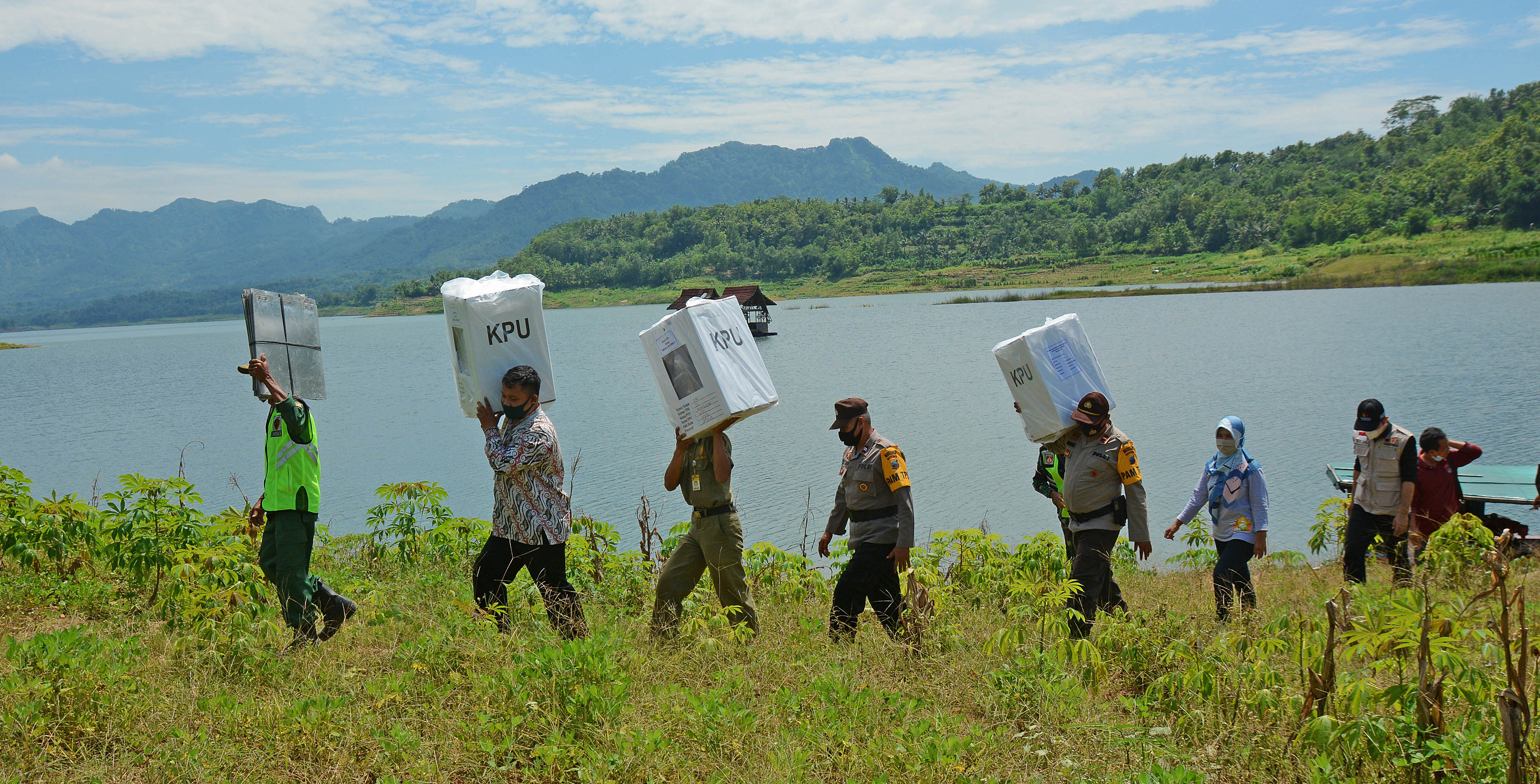 Ilustrasi petugas gabungan membawa kotak suara saat mendistribusikan logistik