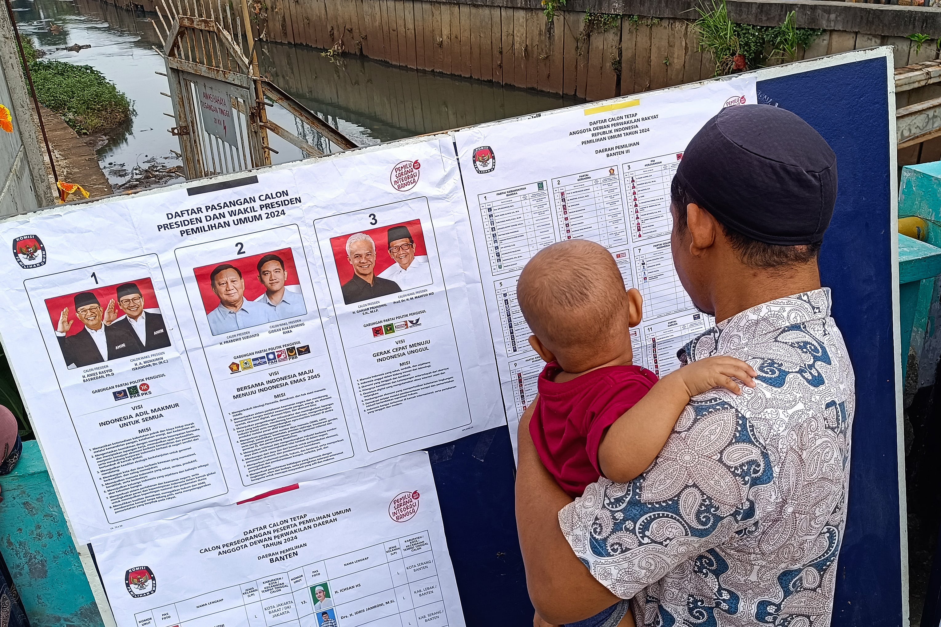 Warga memerhatikan daftar calon sebelum memberikan hak suaranya