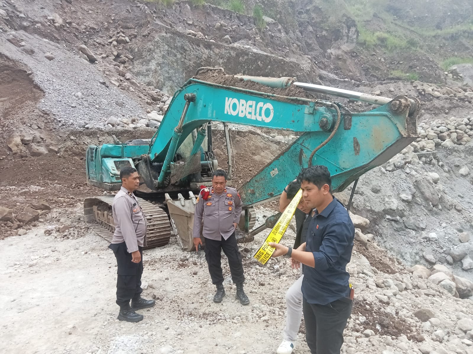 Petugas Polres Garut memasang garis polisi di lokasi galian pasir ilegal yang longsor
