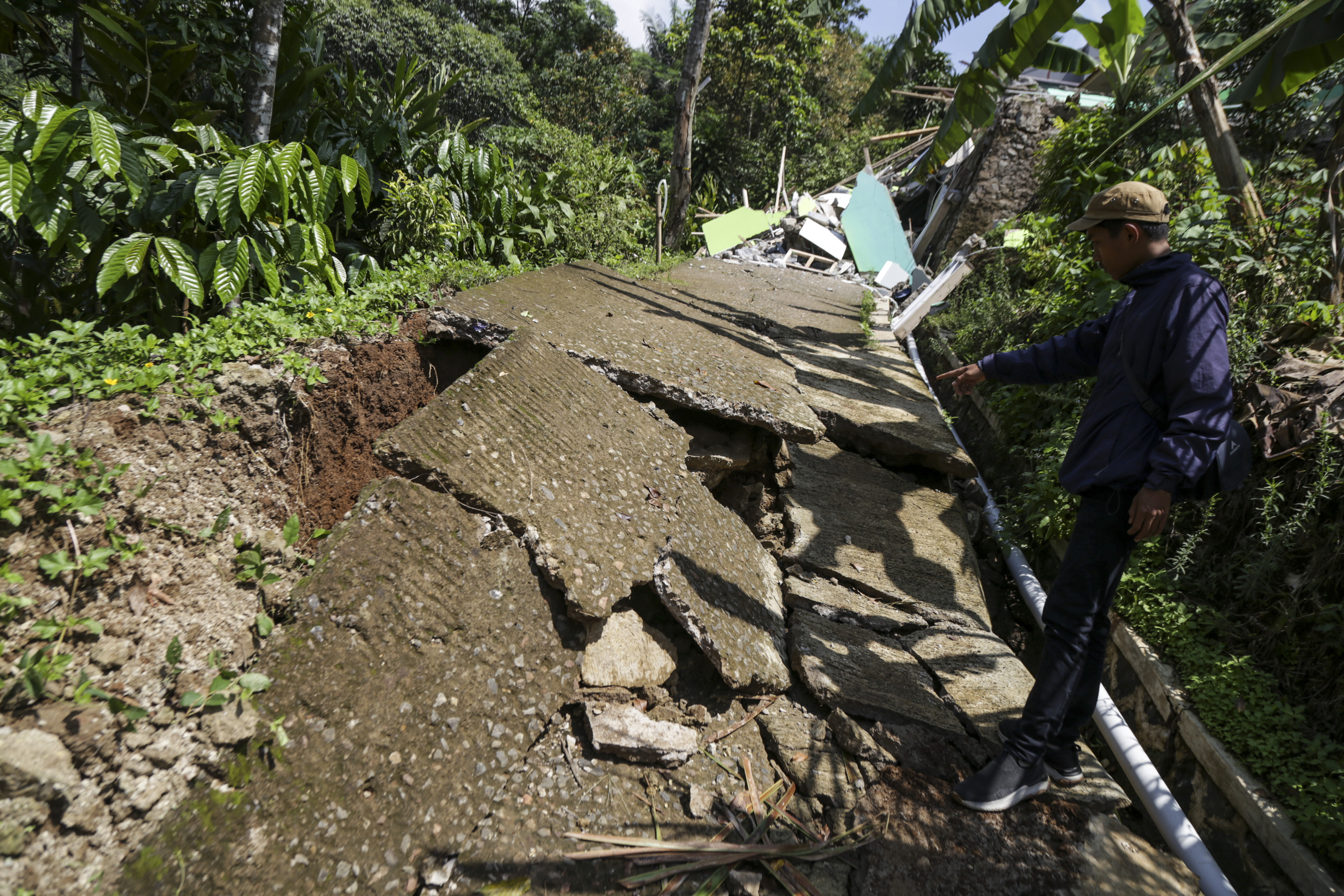 Warga mengamati jalan retak di Tegalkaso, Desa Bencoy, Cireunghas, Kabupaten Sukabumi