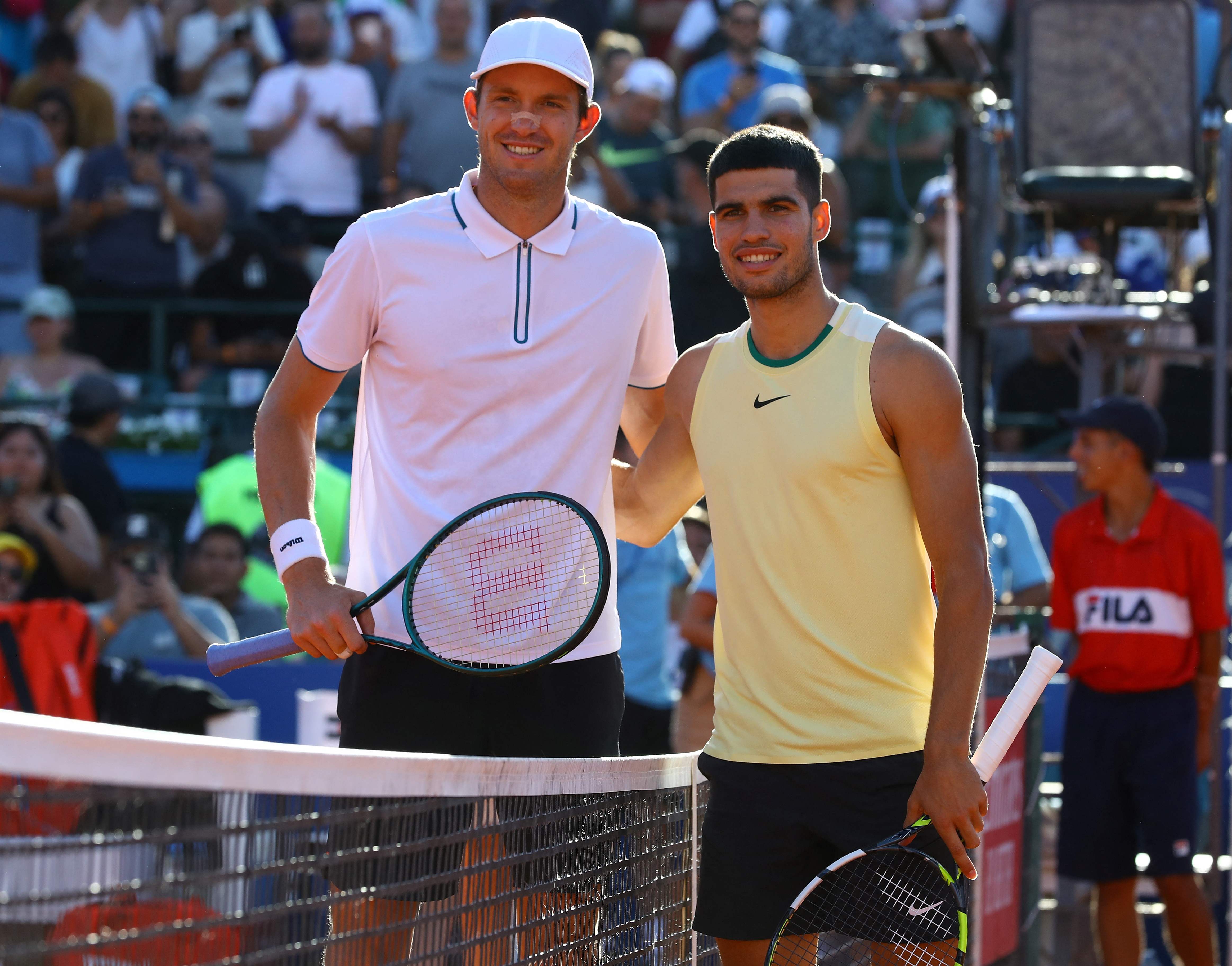 Nicolas Jarry (kiri) dari Chile berjabat tangan dengan Carlos Alcaraz dari Spanyol usai pertandingan, Sabtu (17/2).