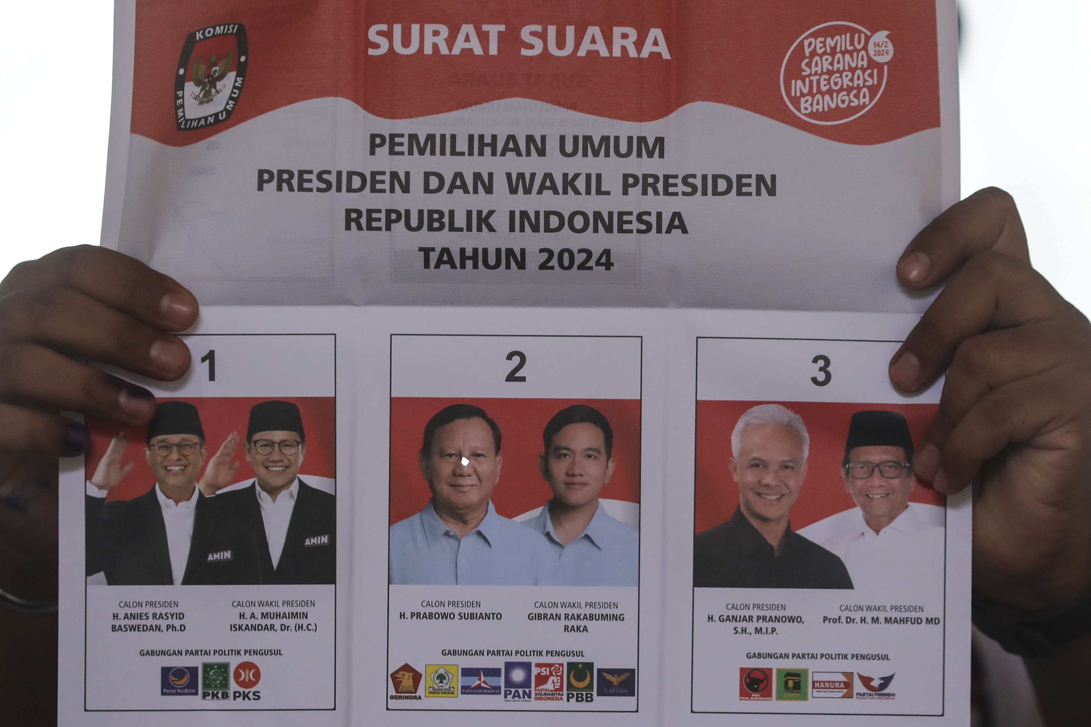 Petugas KPPS menunjukkan surat suara yang tercoplos