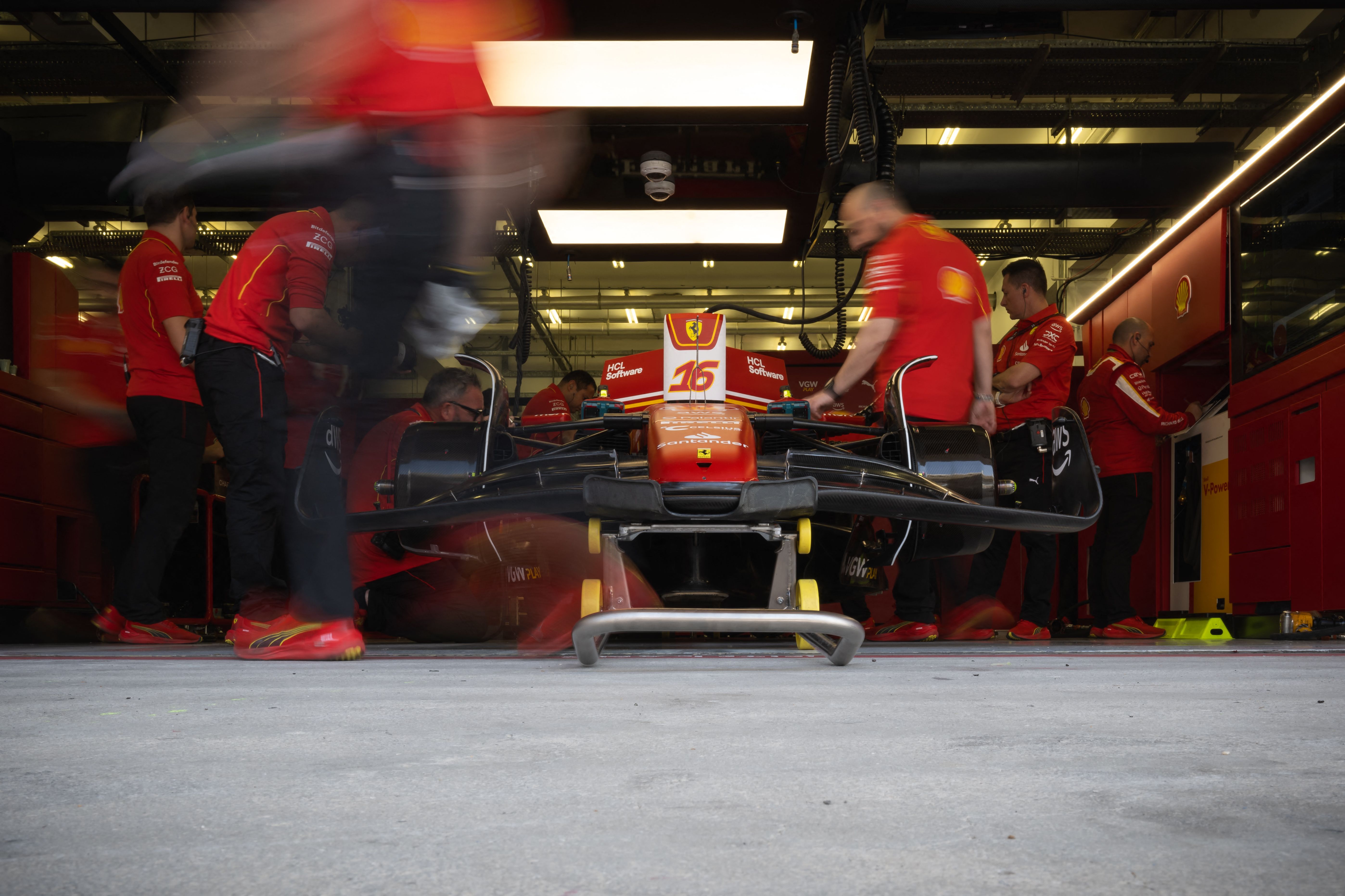 Para teknisi Ferrari tengah menyiapkan mobil Charles Leclerc yang akan digunakan di uji coba pramusim F1 di Bahrain.