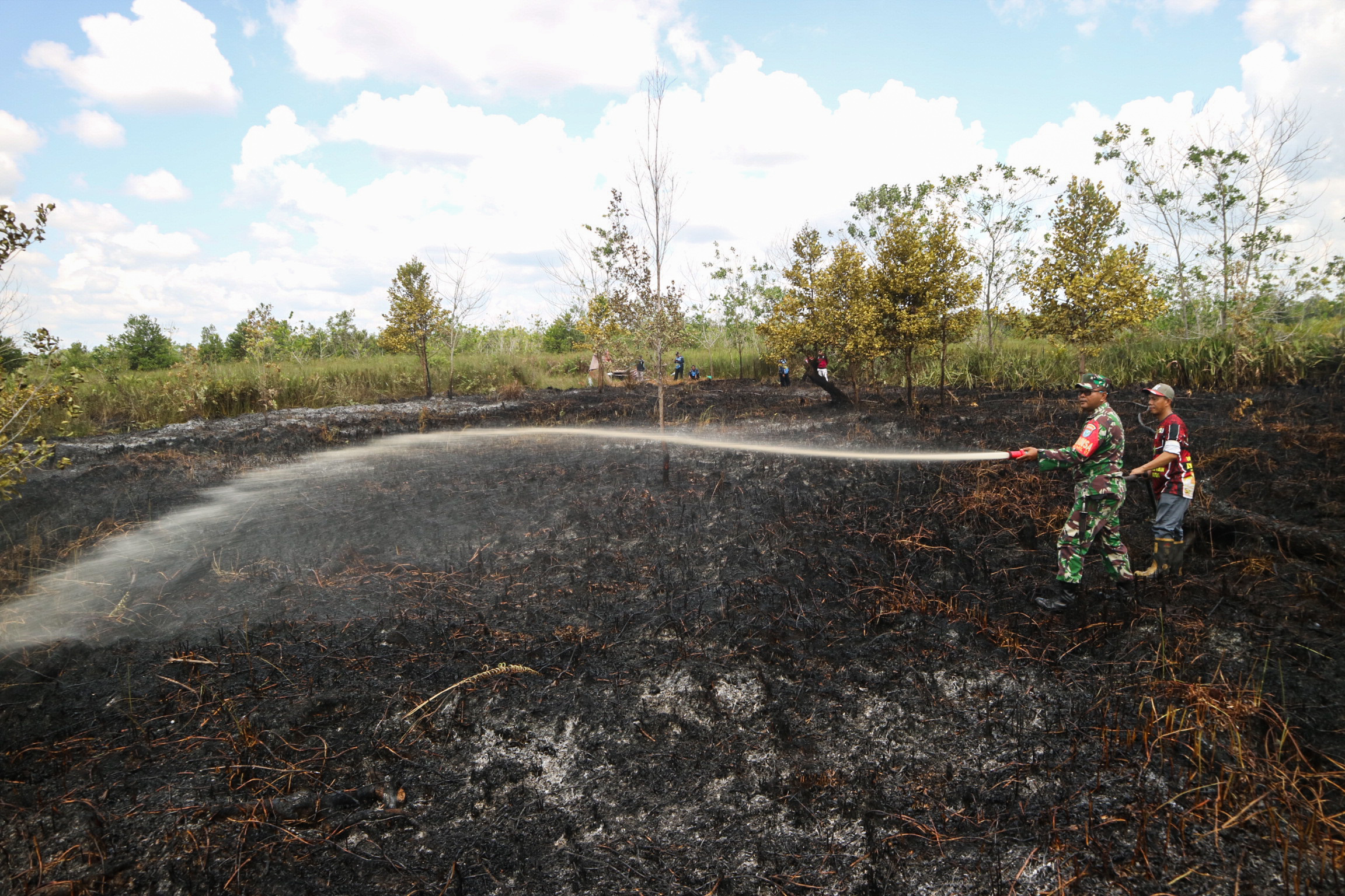 Prajurit TNI melakukan pembasahan lahan gambut yang terbakar di Jalan Dulin Kandang Kelurahan Kereng Bangkirai, Palangka Raya, Kalteng.