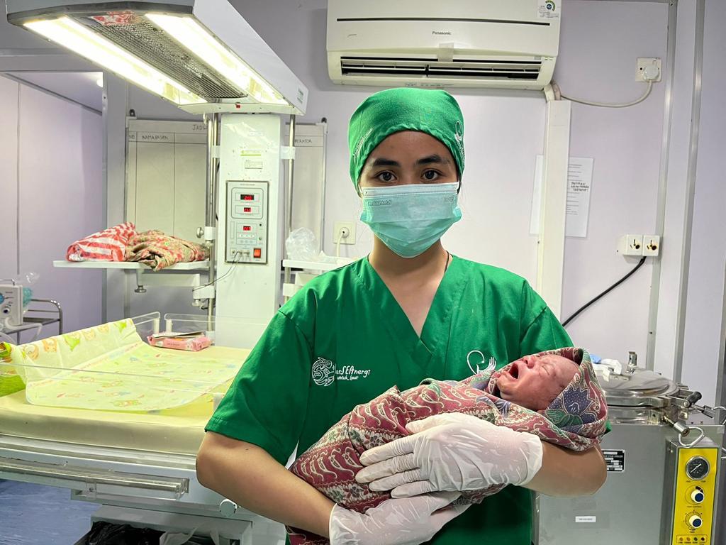  Dokter dari Rumah Sakit Apung Nusa Waluya II menunjukkan bayi yang lahir dan ibunya mendapat bantuan persalinan. 