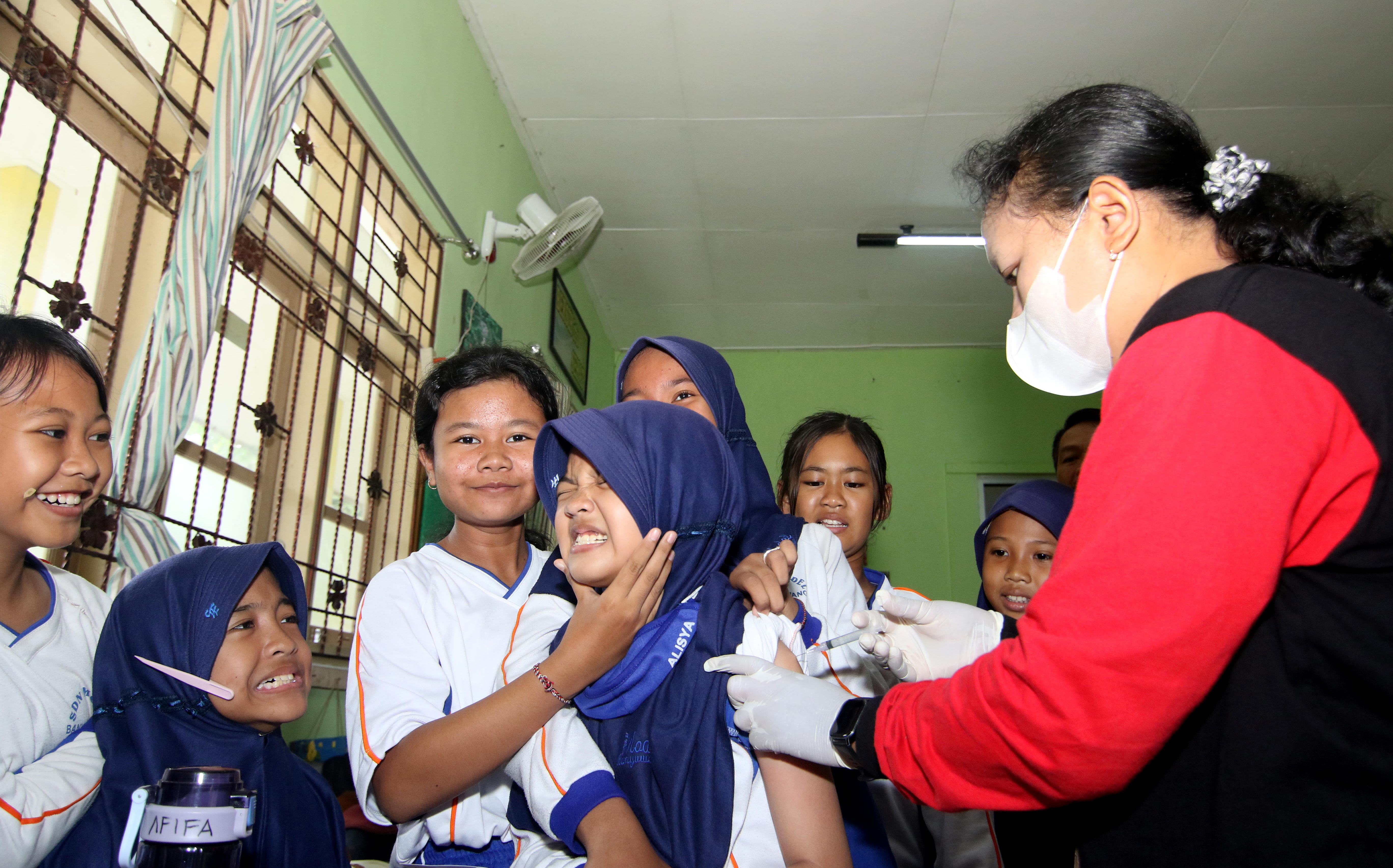 Petugas medis menyuntikkan vaksin Human Papillomavirus (HPV) kepada siswa di SDN Model Banyuwangi, Jawa Timur, Rabu (13/9/2023).