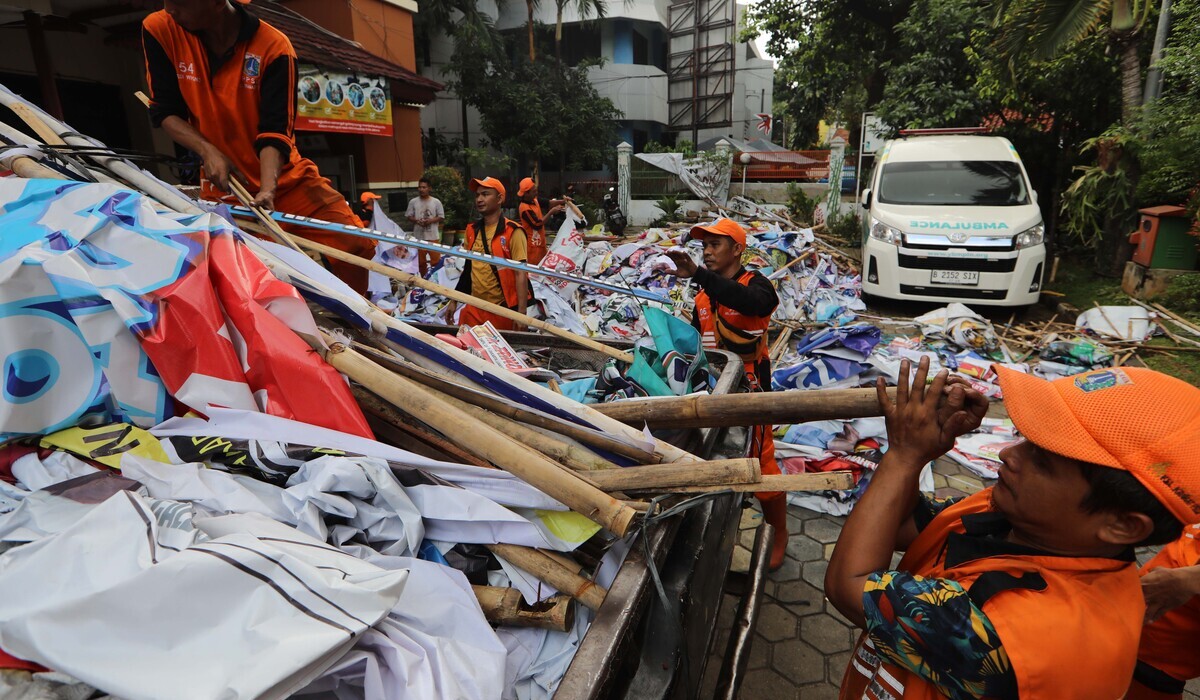 Petugas PPSU menumpulkan alat peraga kampanye (APK) yang sudah dicopot di halaman kantor kelurahan Kramat Pela, Kebayoran Baru, Jaksel.