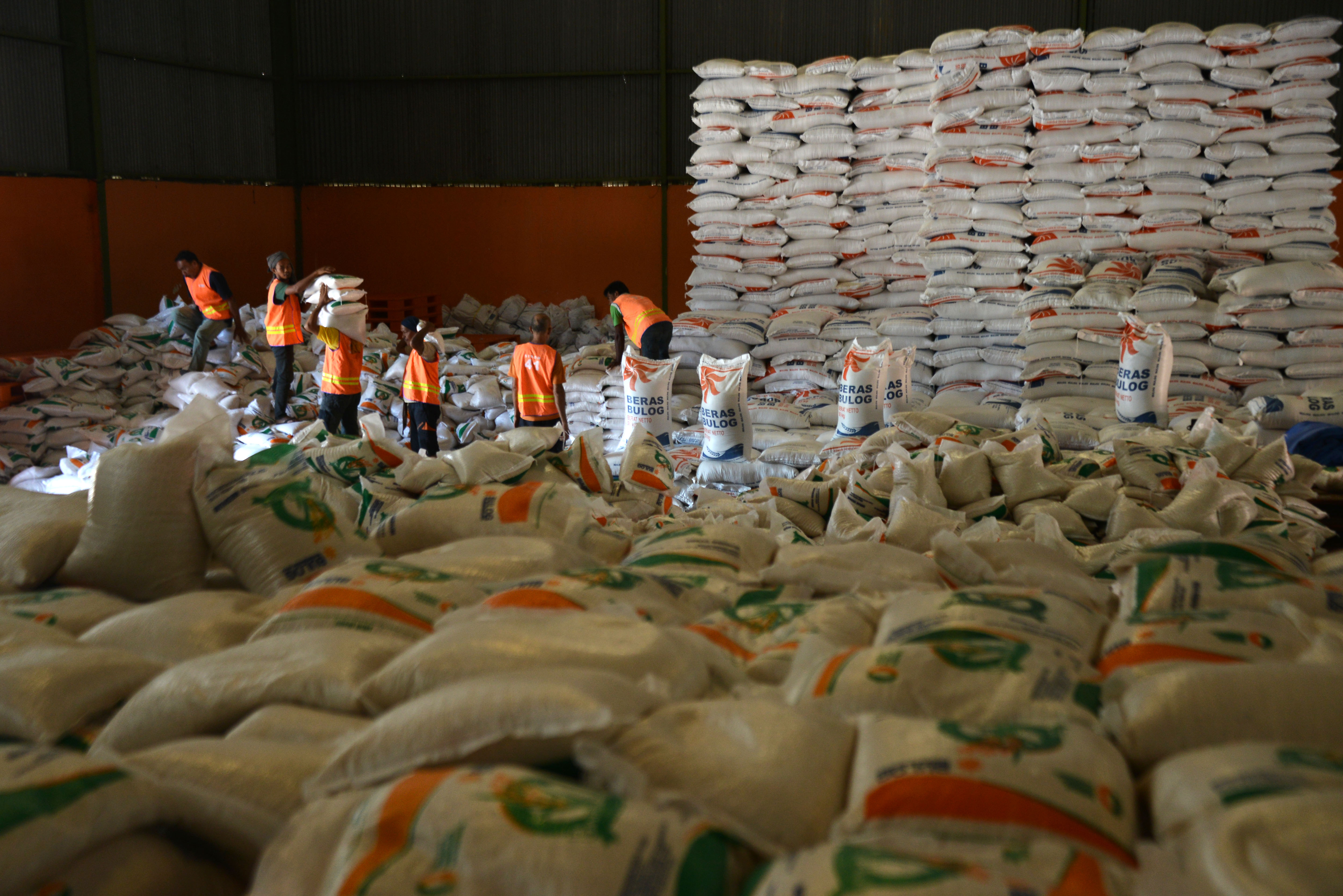 Pekerja menata beras dalam karung di gudang penyimpanan Kantor Wilayah Perum Bulog Aceh, di kabupaten Aceh Besar, Aceh, Selasa (16/5/2023).