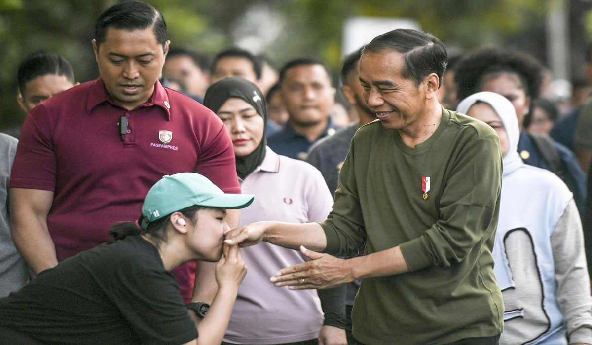 Presiden Joko Widodo (kanan) menyapa warga saat berjalan kaki di Lapangan Gasibu, Bandung, Jawa Barat, Minggu (4/2).